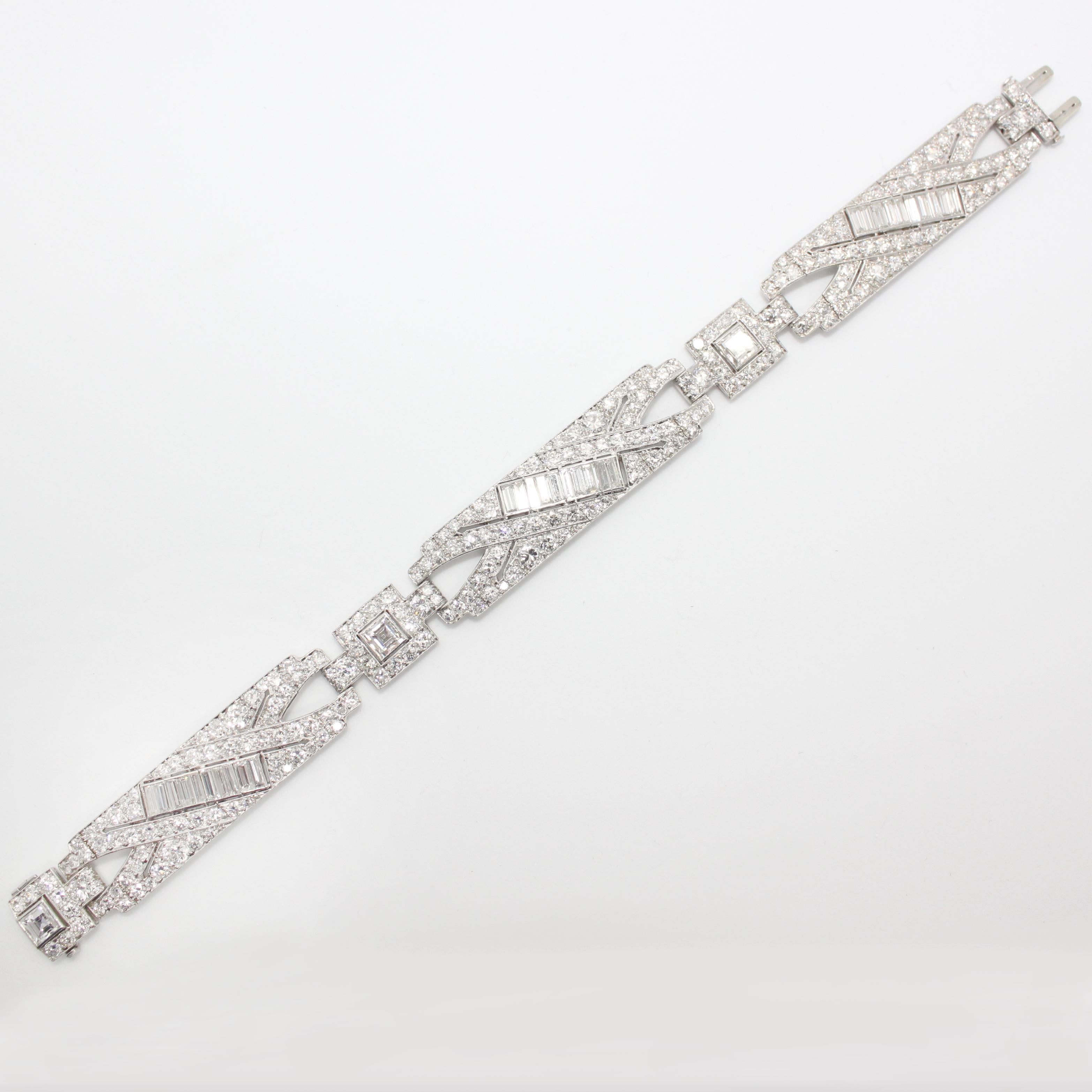 An Art Deco Diamond Bracelet from the 1920s with very fine craftsmanship. The bracelet has three major links and is beautifully studded with square-cut diamonds between the links. The links consist of baguette-cut diamonds and round old-mine cut