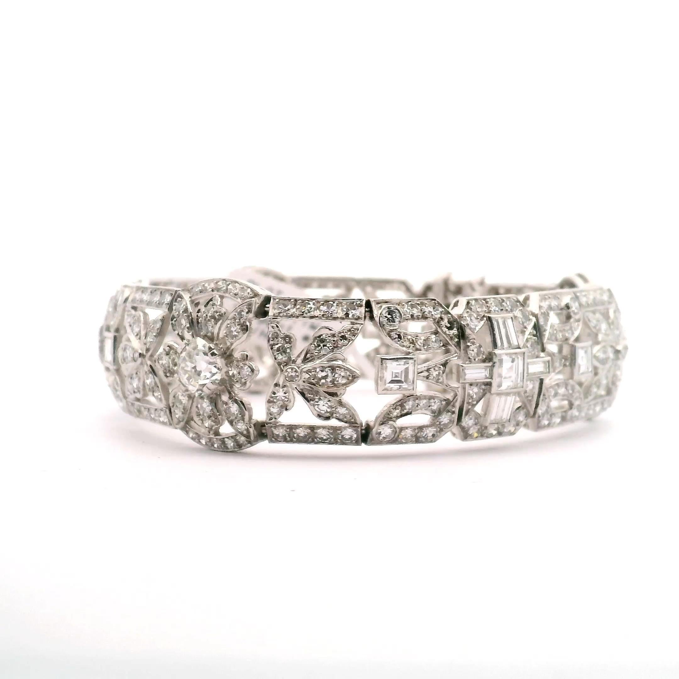 Filigranes Damenarmband mit Bändern und floralen Mustern. Ungefähr 13,96 cttw. an Diamanten,
bestehend aus:

270 Diamanten im Einzelschliff  
9 Diamanten im Quadratschliff 
18 Baguette-Diamanten
3 alte Euro-Schliffe zu je .90 ct.

Platin 55,3 Gramm 
