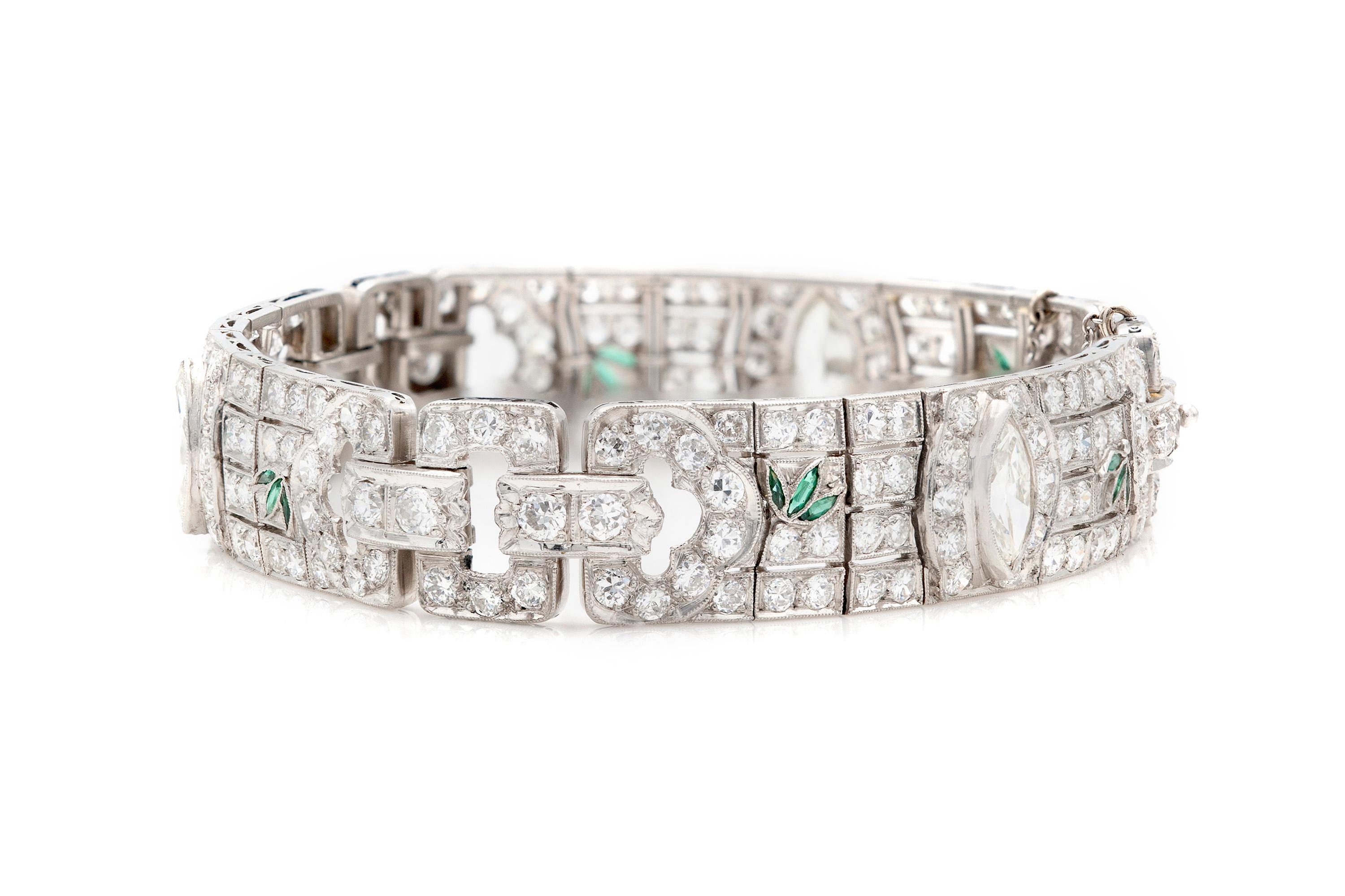 Finely crafted in platinum with three marquise diamonds weighing 2.30 carats total (approximately 0.77 carat each). The bracelet features old euopean-cut diamonds weighing approximately a total of 23.00 carats with accenting emerald.
