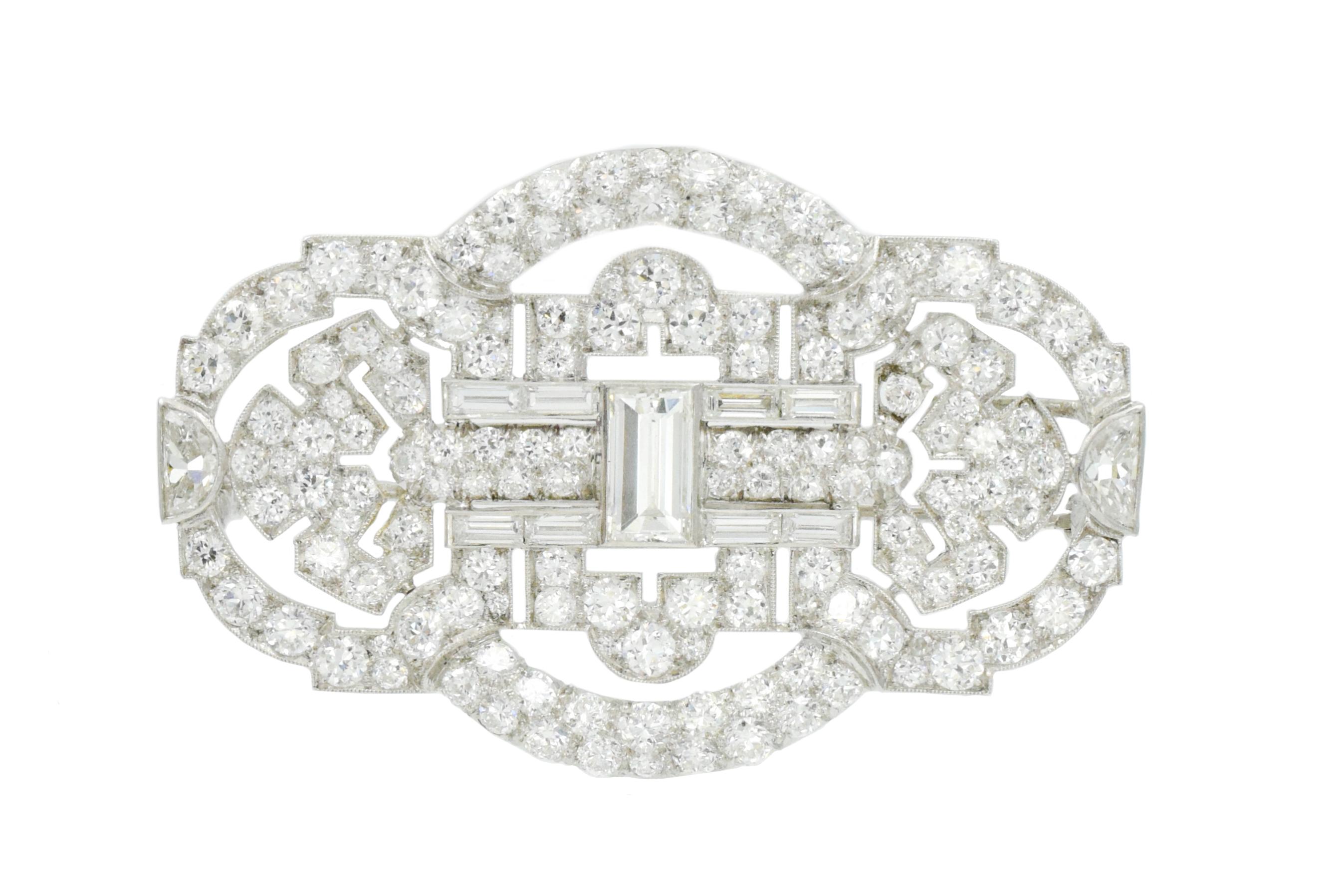 Art Deco Diamond Brooch in platinum. In the center vertically set  baguette cut diamond weighing
approximately 1.00 carat. The rest of this beautiful pin set with old European / round brilliant transitional cut, baguette cut and half moon cut