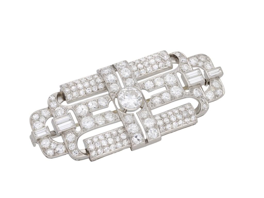 Art deco diamond brooch. Set to centre with one round old cut diamond in an open back rubover setting with an approximate weight of 0.85 carats, surrounded by 45 round old cut diamonds in open back grain settings with an approximate weight of 2.60