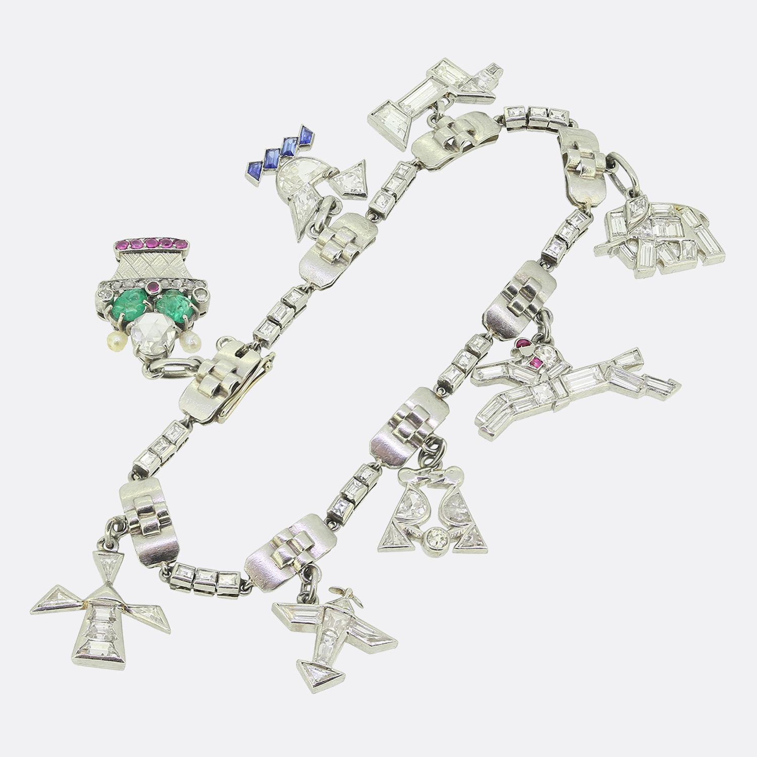 Here we have a stunning life commemorating charm bracelet exuding Art Deco elegance. Sweet and petite in appearance, this platinum piece showcases alternating rectangular links with a cross motif mid section connected via 8 trios of line formed