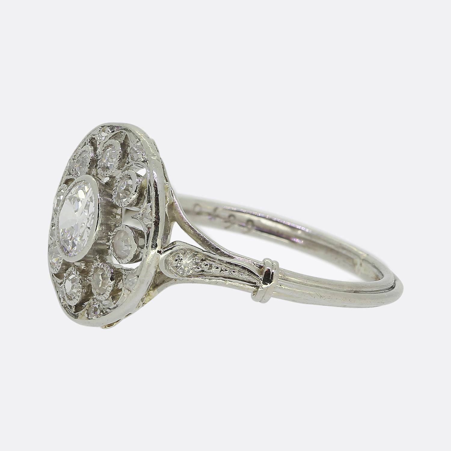 Hier haben wir einen reizvollen Clusterring, der während des Höhepunkts der Art-Déco-Bewegung gefertigt wurde. In der Mitte dieser offenen Seite befindet sich ein einzelner runder, facettierter Diamant im alten europäischen Schliff. Der strahlend