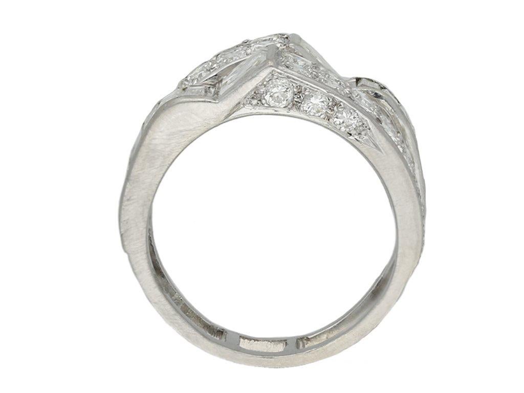Art Deco diamond cocktail ring. Diagonally set with two square step cut diamonds in open back rubover settings with a combined weight of 1.00 carats, each diamond flanked to one side by fourteen rectangular baguette cut diamonds in open back in