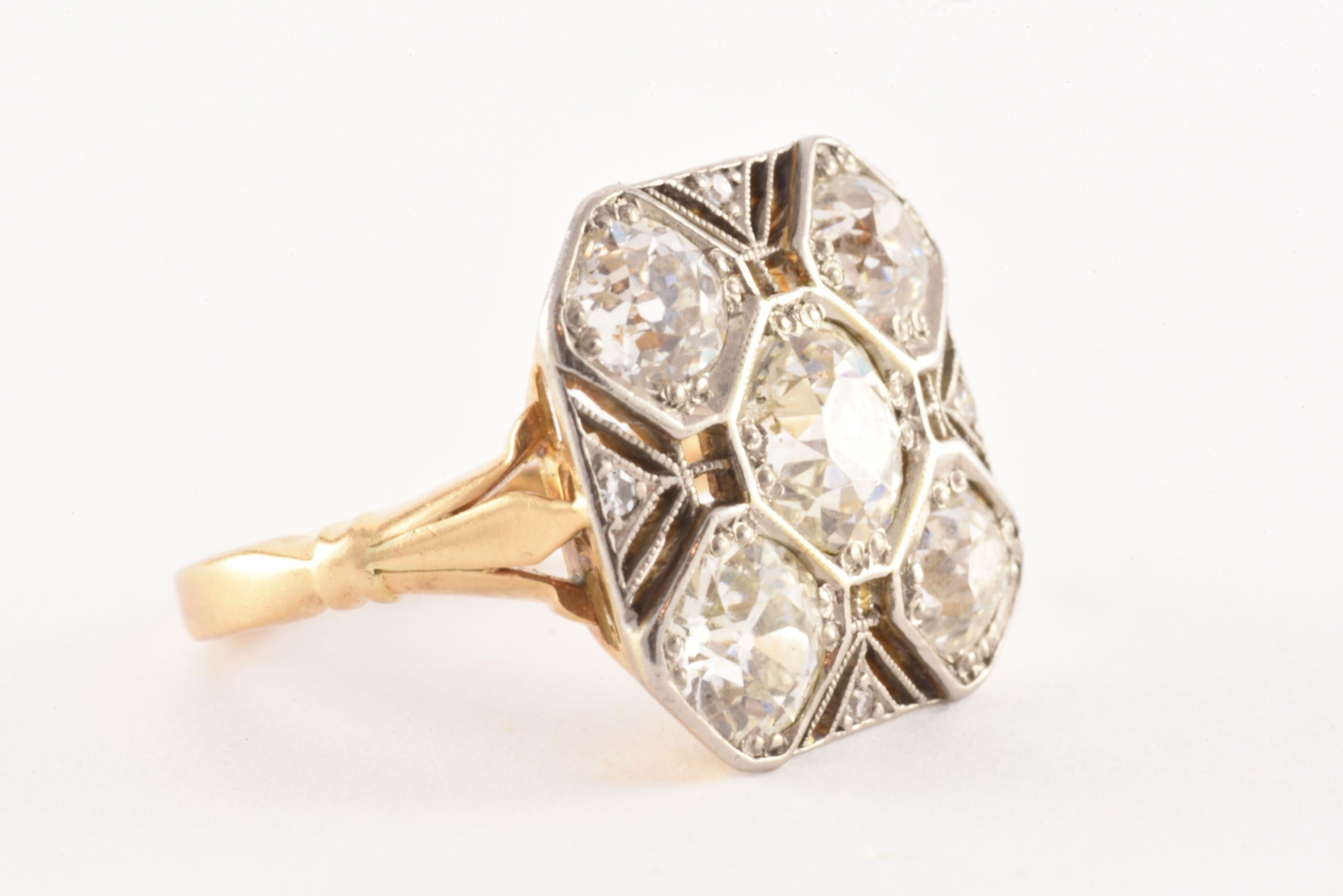 Crafted in the 1930s from 18kt yellow gold and platinum, this stunning two-toned octagonal shaped band features an Old European cut diamond center stone weighing approximately 1.15 carats, G color, SI clarity, surrounded by four Old European cut