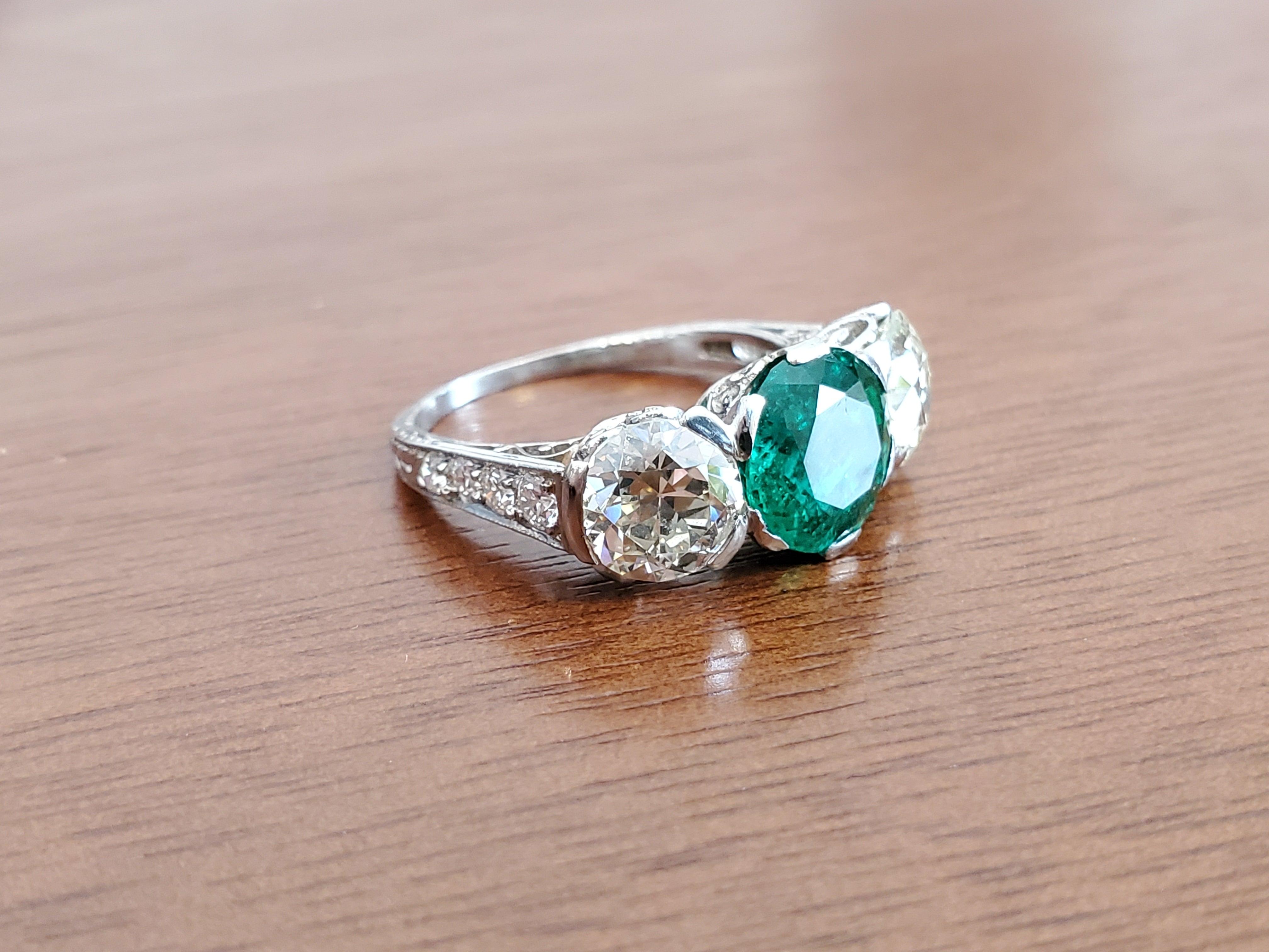 Listed is an original Art Deco Platinum Old European Diamond and Colombian Emerald Ring. There are approximately 3.00 carats of KL color VS-SI1 old European diamonds and a 2.58ct old cut round Colombian Emerald center stone. The color of the emerald
