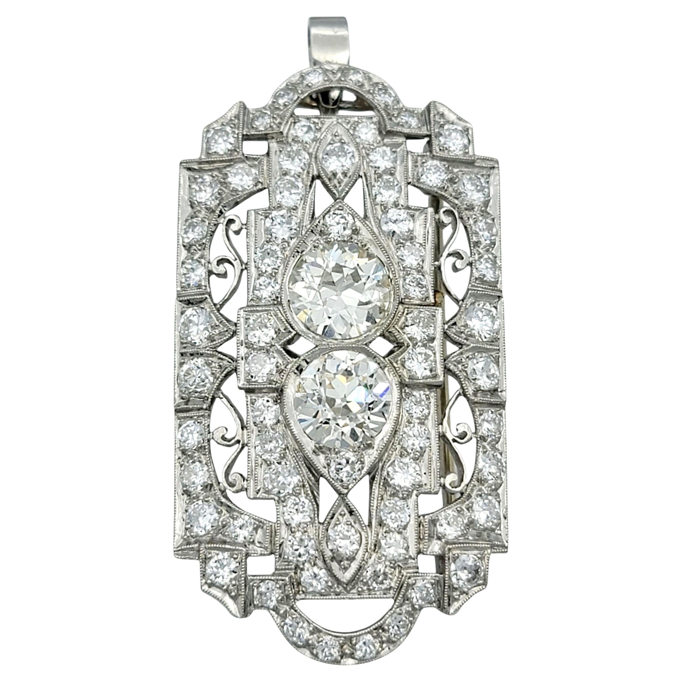 Questo squisito ciondolo e spilla convertibile in stile Art Déco emana un'eleganza senza tempo e un'intricata maestria. Disegnato in oro bianco 14 carati, il pezzo presenta un motivo geometrico traforato che incarna l'audace simmetria dell'epoca Art