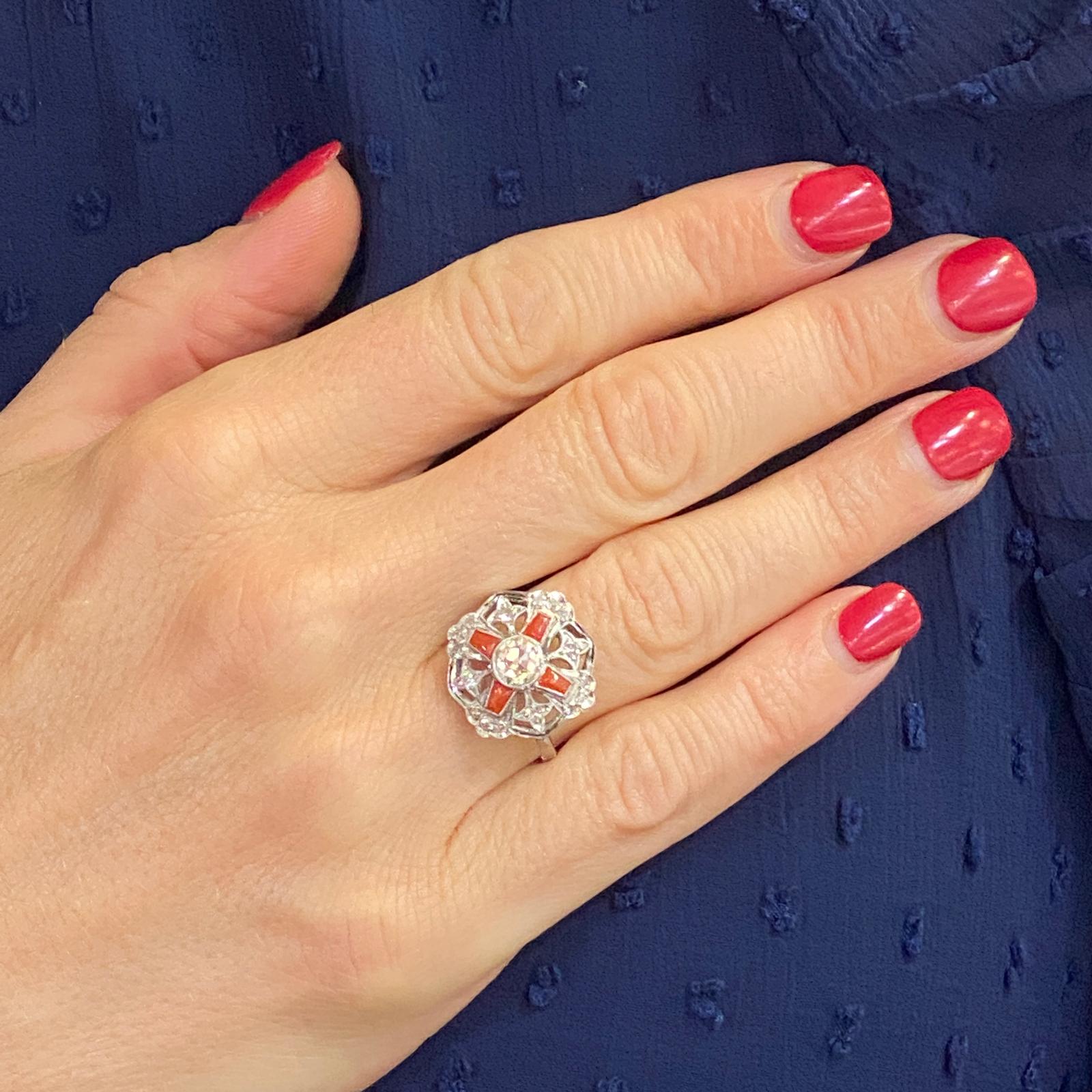Original Art Deco Diamond and Coral Ring handcrafted in platinum. The filigree ring features a center .50 carat old European cut diamond, another .20 carat total weight of side diamonds, and 4 coral accents. The ring is currently size 7 (can be