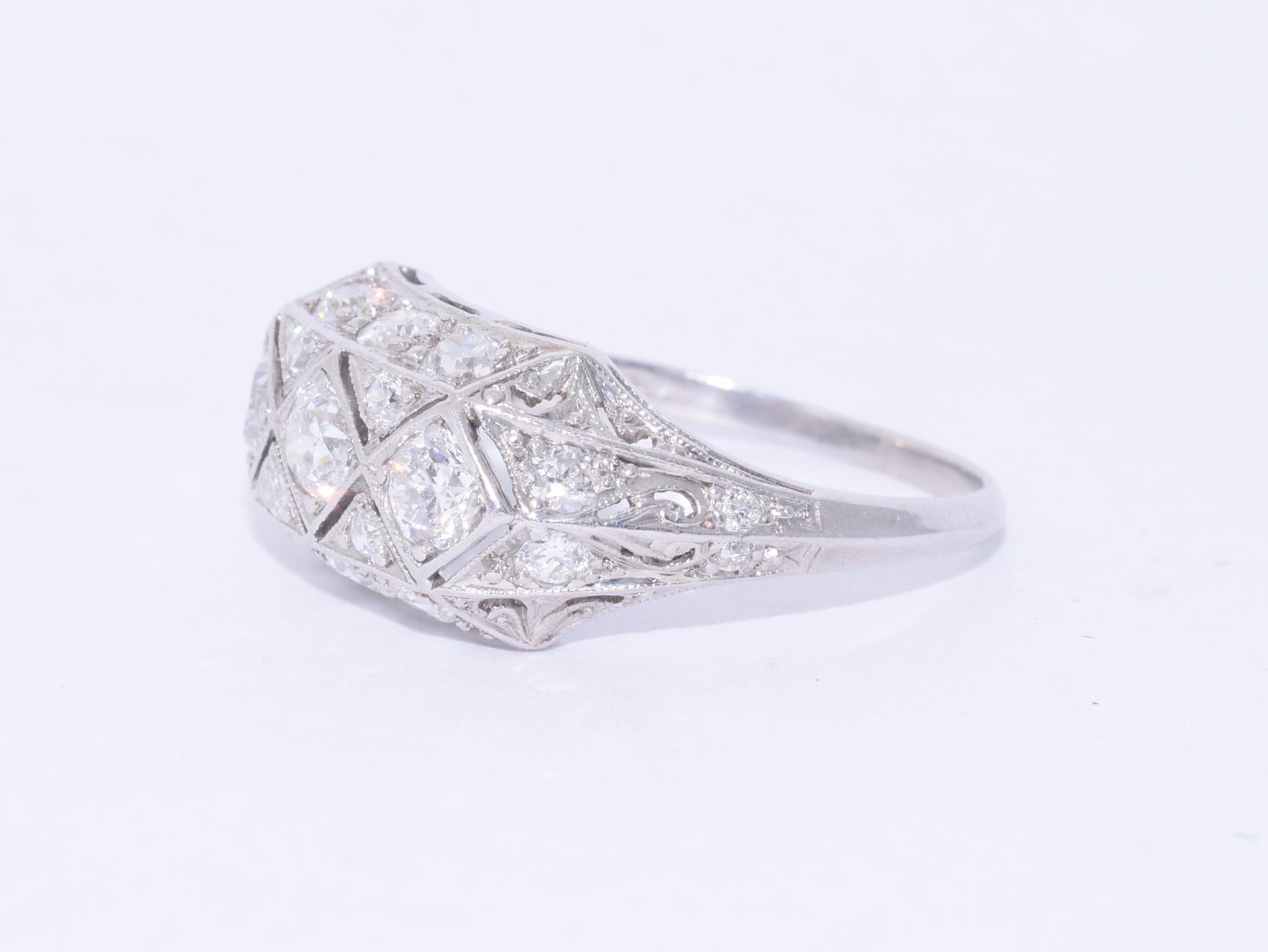 Round diamonds totaling approximately 1.30 carats are mounted in a patterned platinum ring. The ring is currently a size 7.5 and measures approximately 3/8 inch wide.