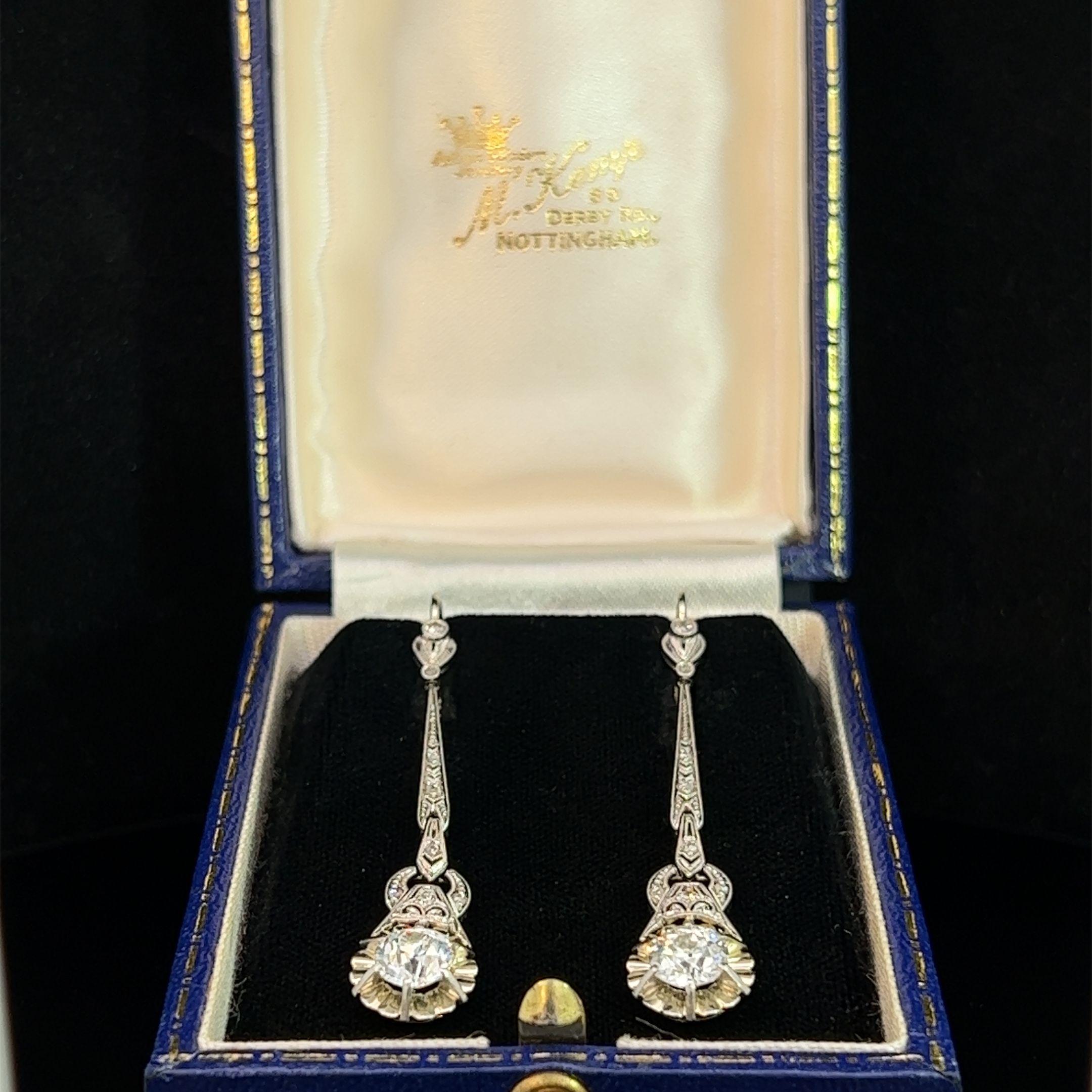 A pair of 18ct & Platinum, diamond set, Art Deco drop earrings. Each earring is claw set at the base with an Early European Brilliant Cut Diamond on an articulated long drop set with single and rose cut diamonds, fitted with continental