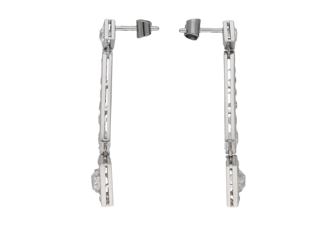 Art Deco diamond drop earrings. A matching pair, each surmounted with a round old cut diamond in an open back grain setting, two in total with a combined approximate weight of 0.60 carats, each suspending seven graduating round old cut diamonds in