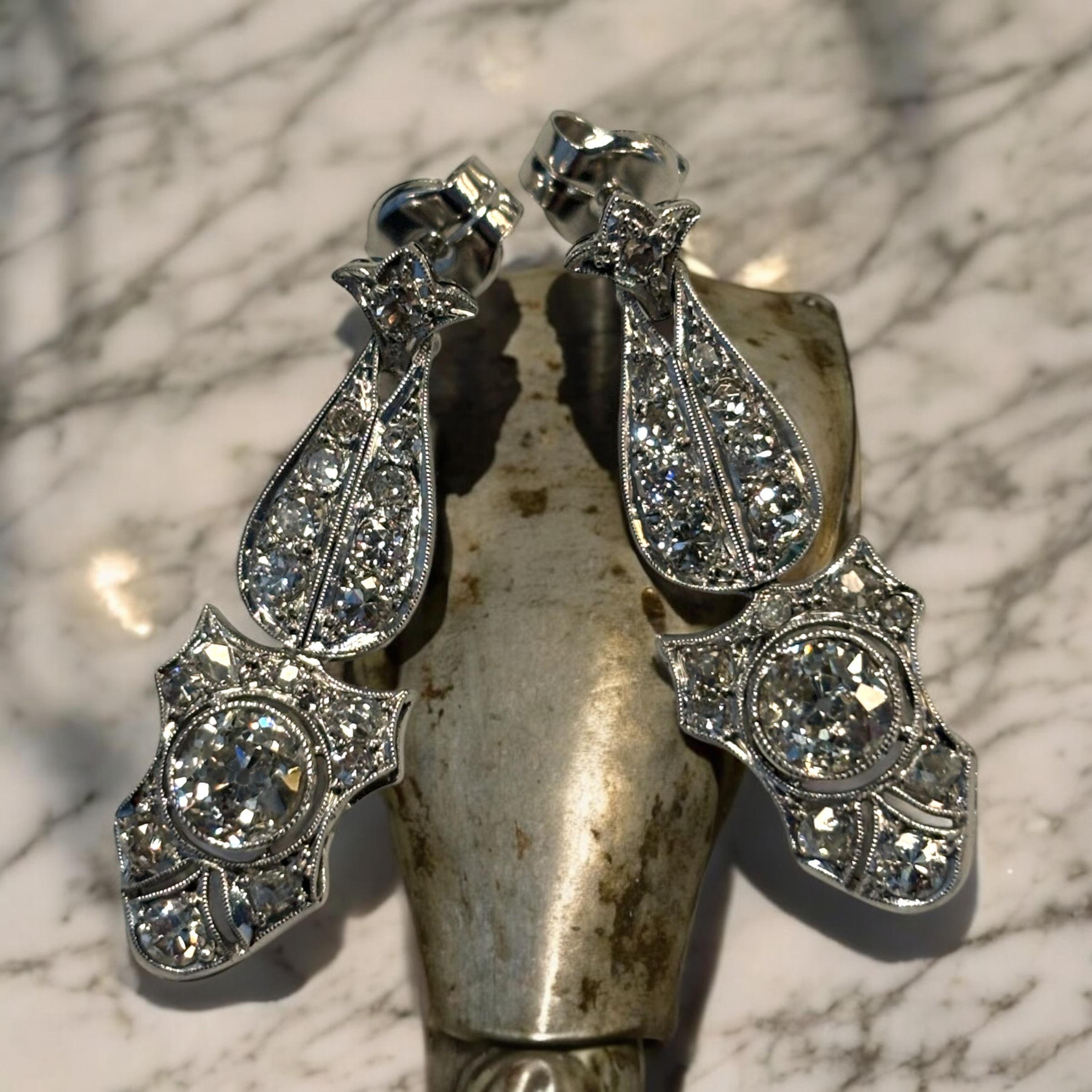 Exquisitely detailed Art Deco Antique Diamond drop earrings.
These platinum earrings drop elegantly from the ear with the motion of the articulated drop setting the diamonds into sparkling action.
A matching pair, each surmounted with a round old