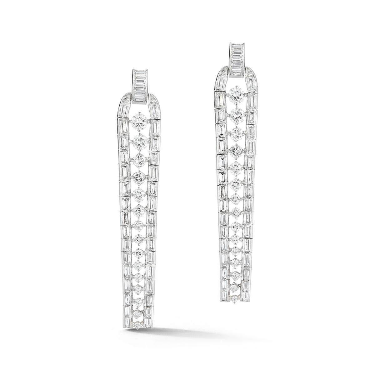 Lineare dreireihige Diamantohrringe, 2 Reihen von Diamanten im Baguetteschliff umgeben eine Reihe von abgestuften Diamanten im Rundschliff, alle in Platin gefasst.
80 Diamanten im Baguetteschliff und 30 Diamanten im Rundschliff

Abmessungen: 2.5