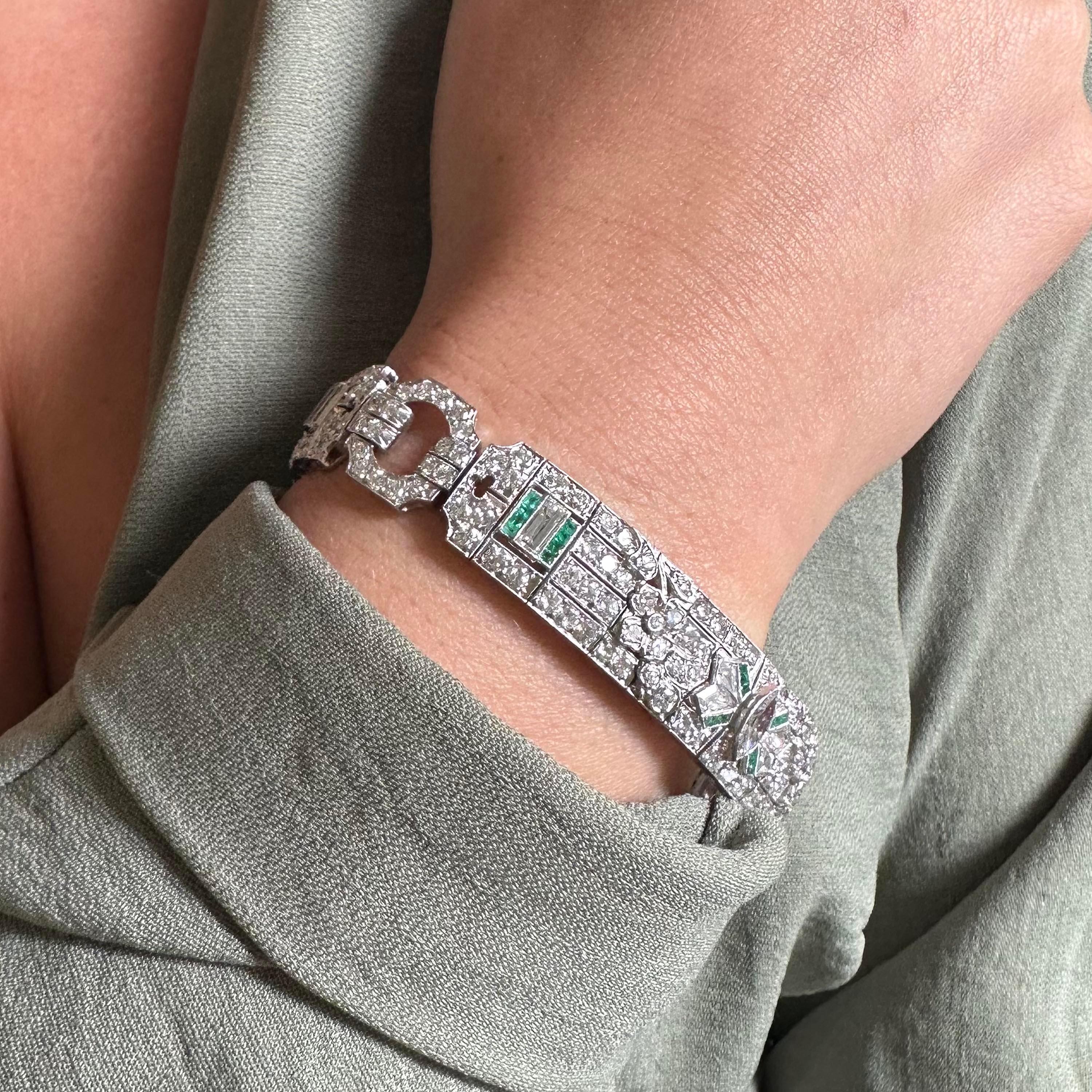 An Art Deco diamond emerald and platinum bracelet, featuring three geometric plaques, set with marquise, baguette, kite cut and round brilliant-cut diamonds, with square step-cut emeralds, mounted in platinum, stamped 10% irid plat, numbered 27700,