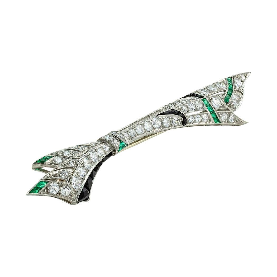 Art Deco old European-cut diamonds emeralds onyx and platinum bow brooch circa 1925. *

SPECIFICATIONS:

GEMSTONES:  calibrated emeralds and French-cut black onyx.

DIAMONDS:  forty-six old European and single-cut diamonds totaling approximately