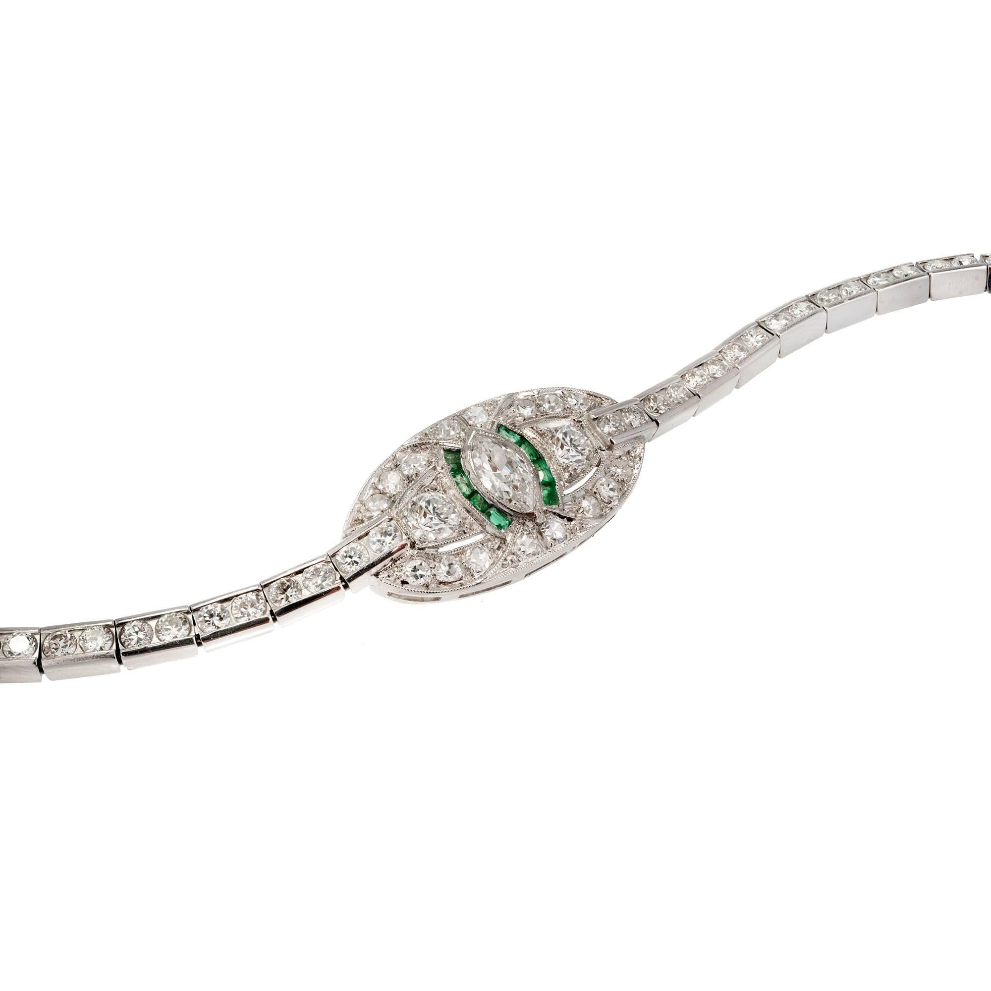 Beautiful vintage 1940s Platinum bracelet set with a Marquise center Diamond flanked by genuine Emeralds in the bead set center section on a channel set Platinum hinged link Diamond bracelet with a build in hidden catch and secure underside