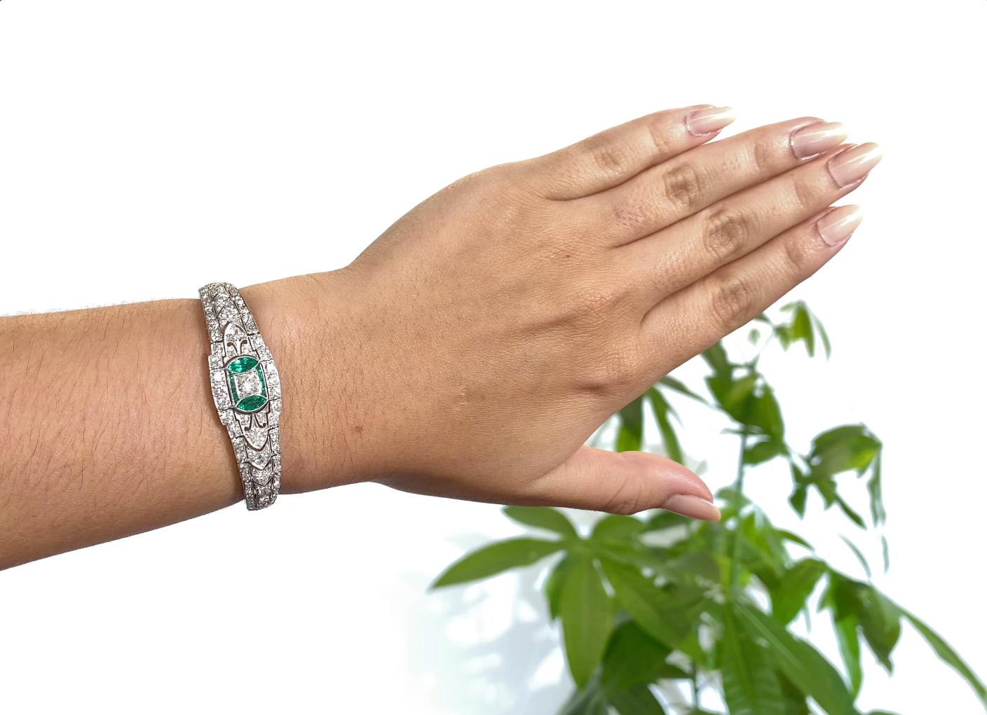 Art Deco Diamond Emerald Platinum Bracelet. The bracelet features 113 diamonds, approximately 5.50 carats (center diamond is approximately 0.45 carat) G-H color, VS clarity. Accented by 10 emeralds, approximately 0.60 carat. Circa 1920s. 6 1/4