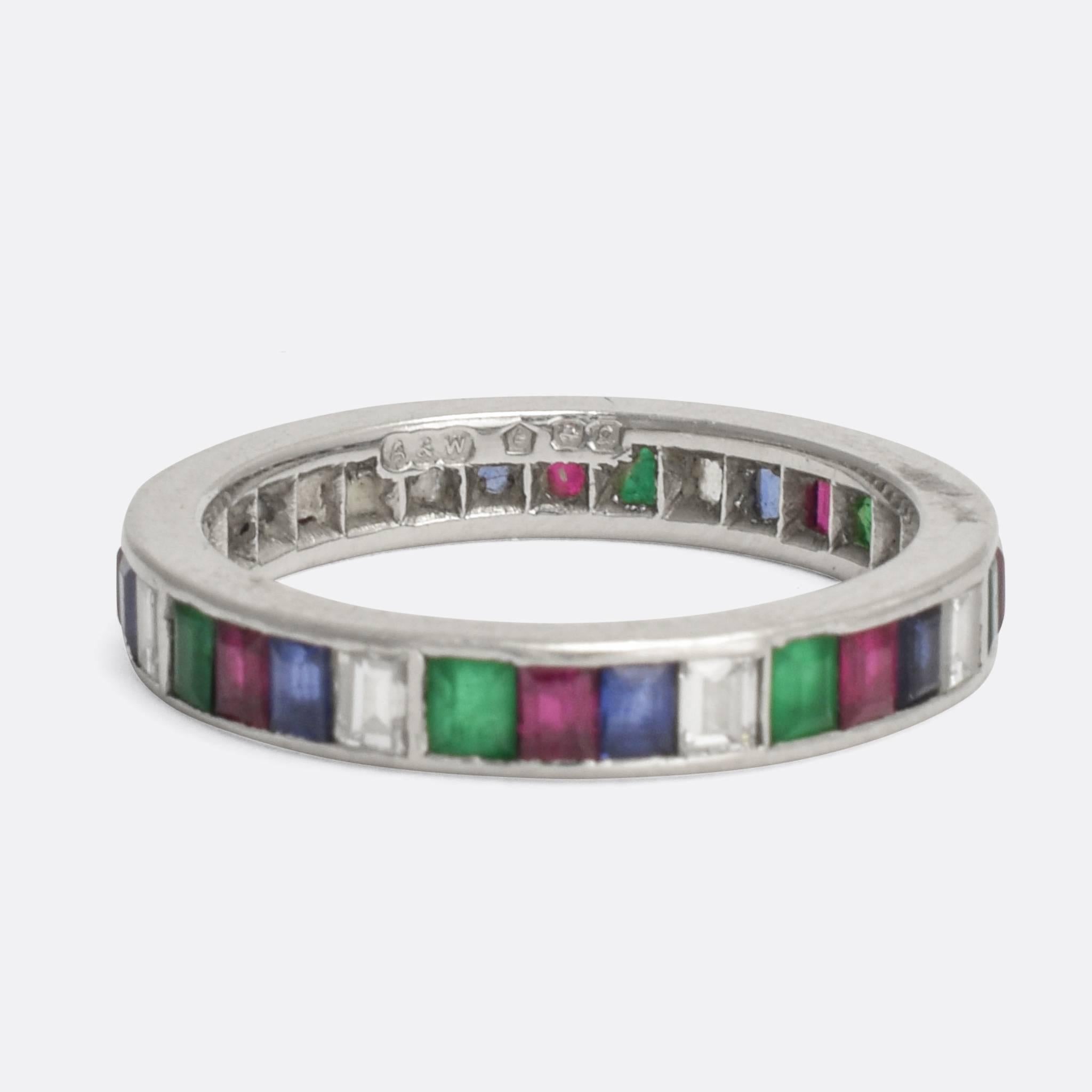 A stunning multi-gem eternity ring dating from the Art Deco period, circa 1930. It's set with White Diamonds, Blue Sapphires, Rubies and Emeralds, and modelled in platinum throughout. A quality piece with the elegant styling and bold colours typical