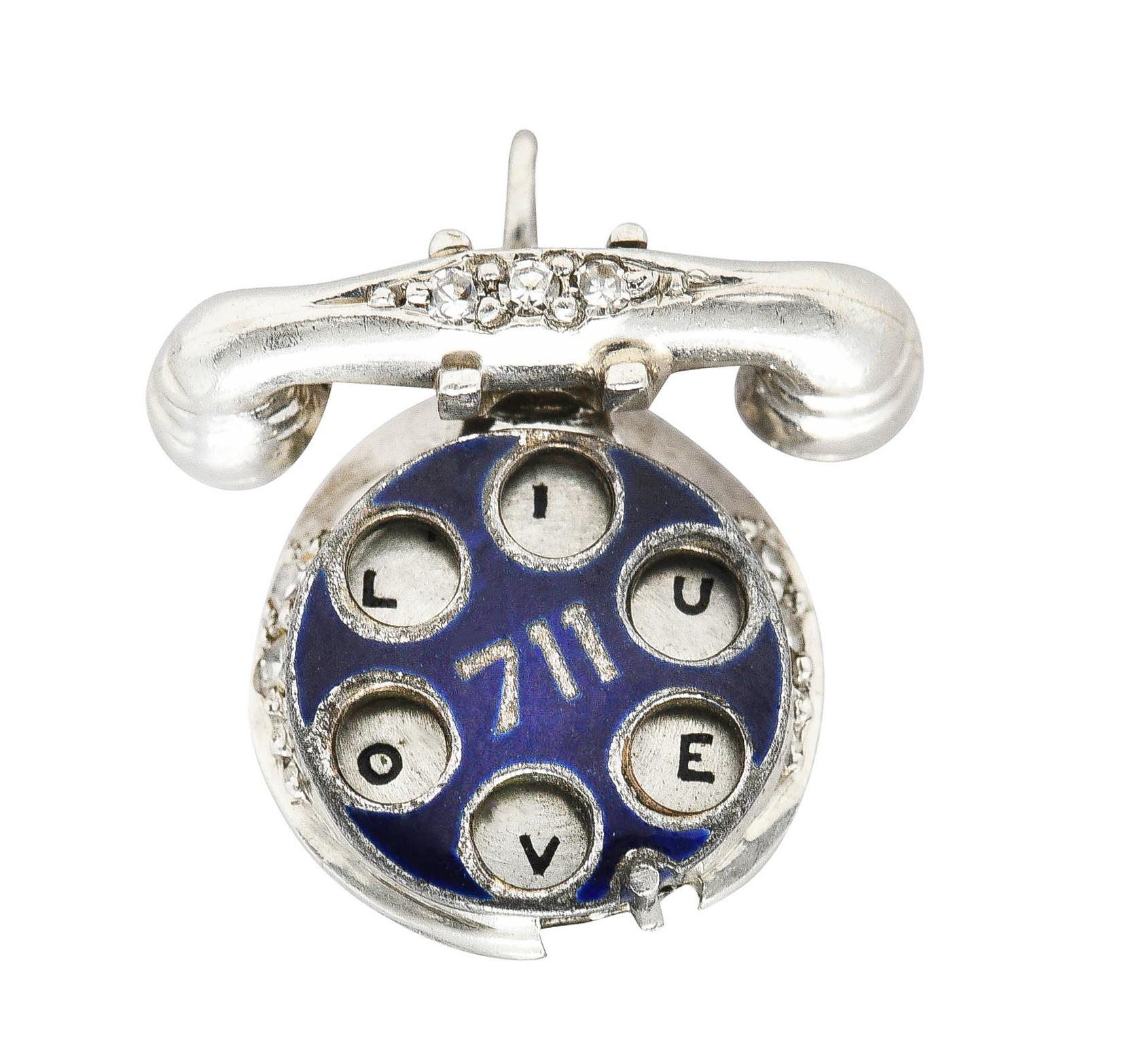 Designed as a rotary phone featuring enamel dial. Opaque navy blue - exhibiting minimal loss. Centering the number '711' and rotates. Spelling out 'HELLO! I LOVE U'. Accented by single cut diamonds. Weighing approximately 0.06 carat total. Eye clean