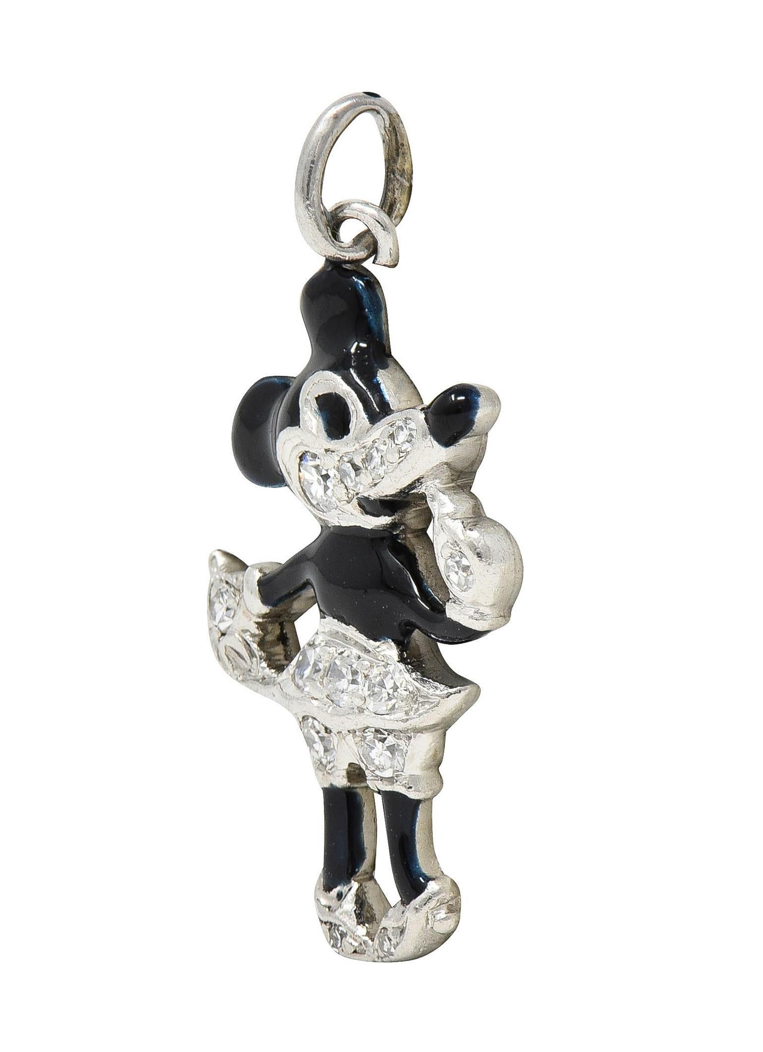Designed as an early depiction of the Disney cartoon character Minnie Mouse
Depicted standing and wearing a skirt and heels with finger to chin 
Body and nose are glossed with opaque bluish-black enamel - minimal loss
Face, hands, shoes, and skirt