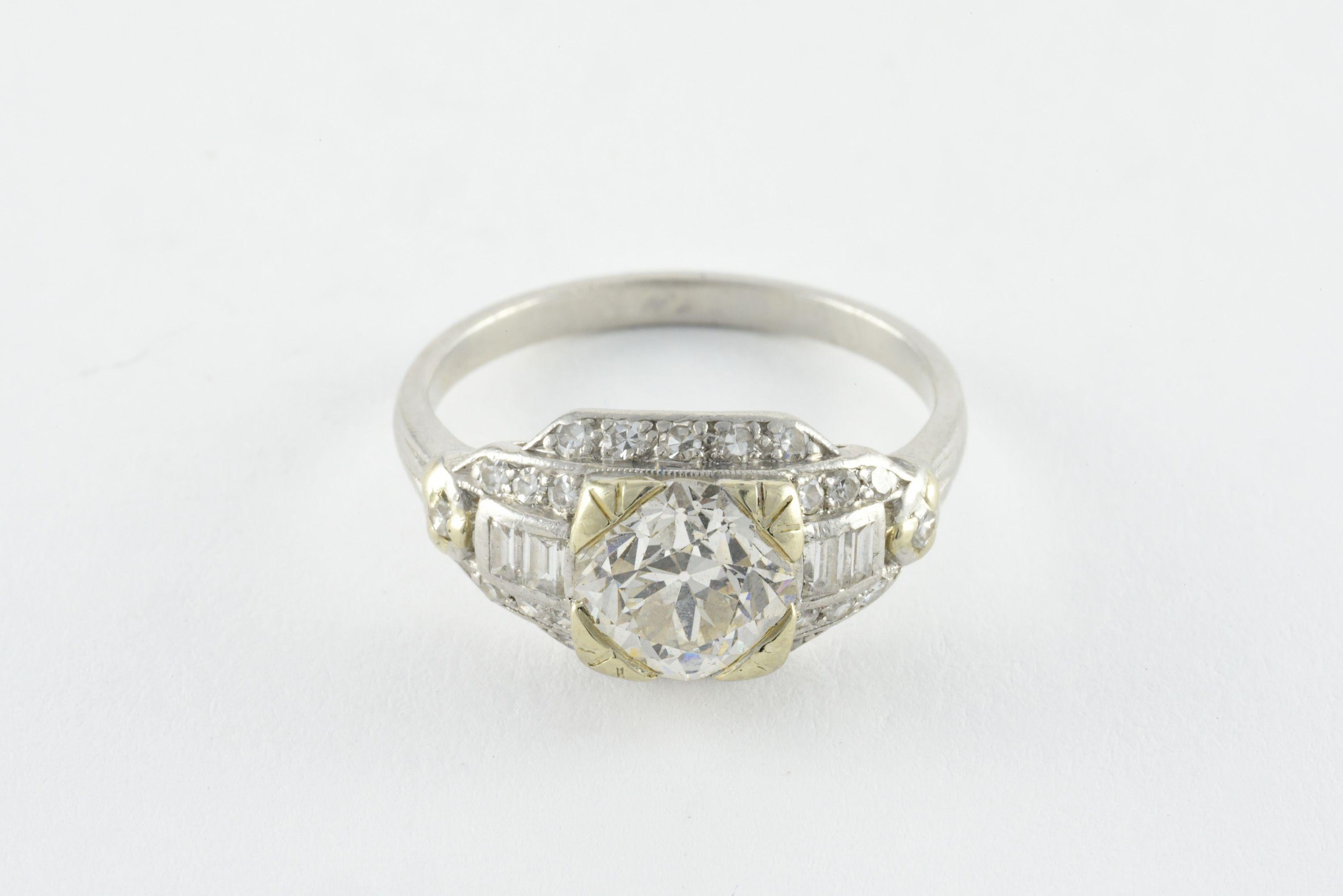 Crafted in the 1920s from platinum and 18kt yellow gold, this Art Deco gem features an Old European cut center stone totaling approximately 1.75 carats, K color, VS clarity and measuring 7.57 x 7.42 x 5.10mm. It is flanked by baguette-cut diamonds