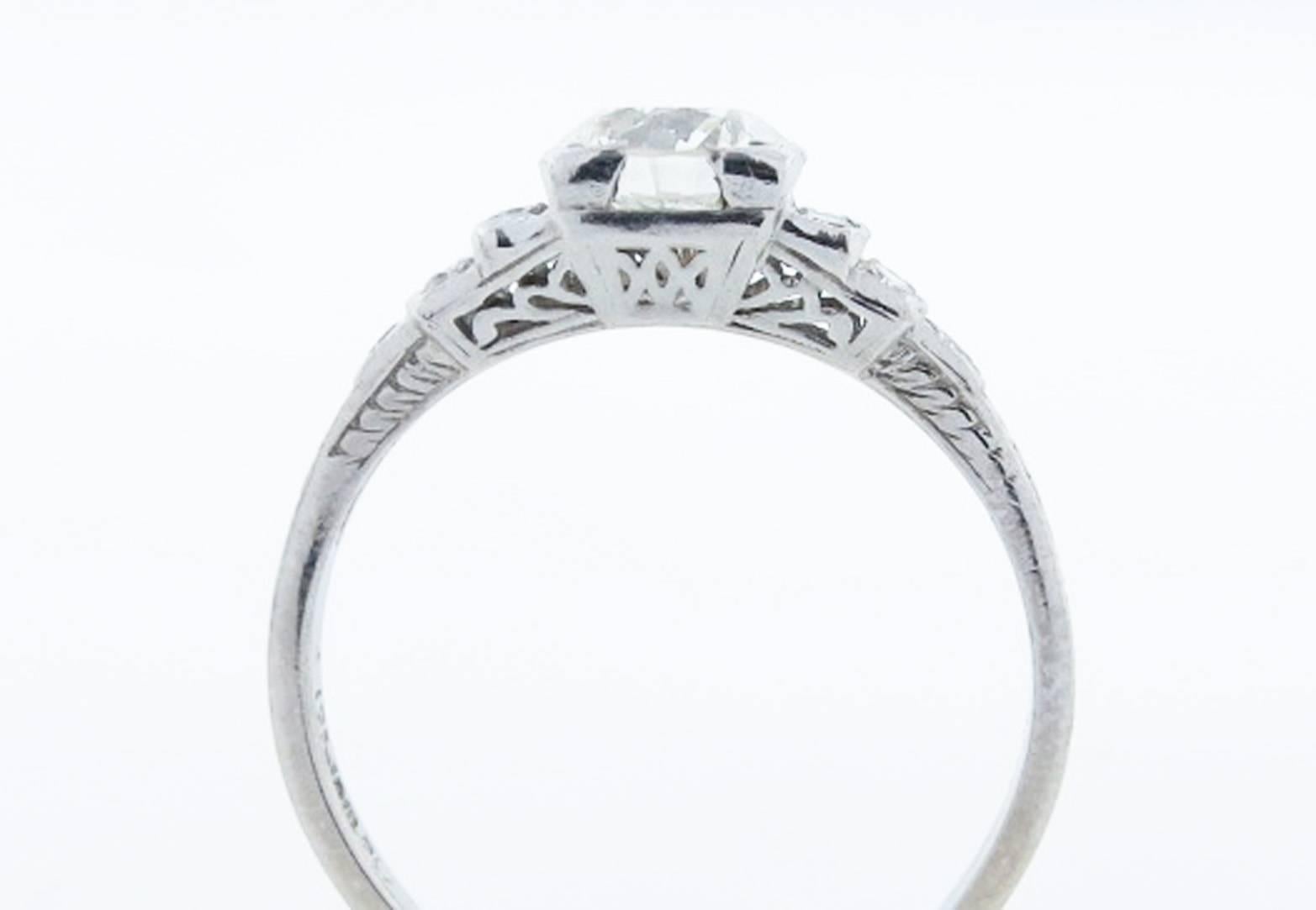 Handmade platinum mount antique diamond ring circa 1920. The center is box set with a round European cut diamond weighing approx .80cts. grading VS clarity J color. The lovely open work engraved mound is stepped down with 6 round European cut