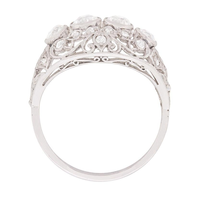 This cluster ring is a fabulous handmade piece of jewellery. It features four rub over set diamonds, the two in the middle weighing 0.40 carat each and the two on the outside 0.25 carat each. Within the filigree work surrounding, there is a further
