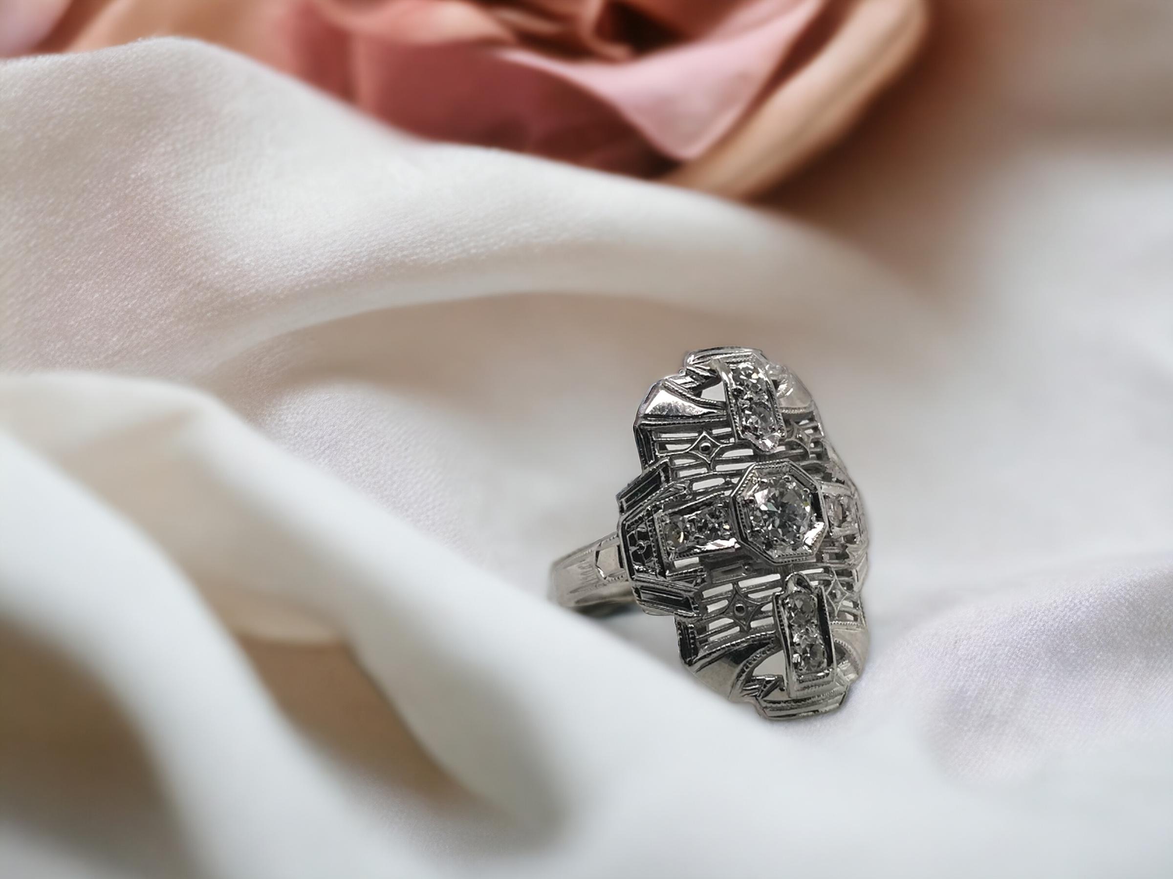 Questa bellezza è super dettagliata!
Ci piacciono le sue proporzioni, perfette per quasi tutte le mani, non troppo lunghe.

Dettagli dell'anello
Materiale: oro bianco 18 carati
Epoca: Art Deco 1920 - 1940
Lunghezza della testa: 20 mm
Larghezza della