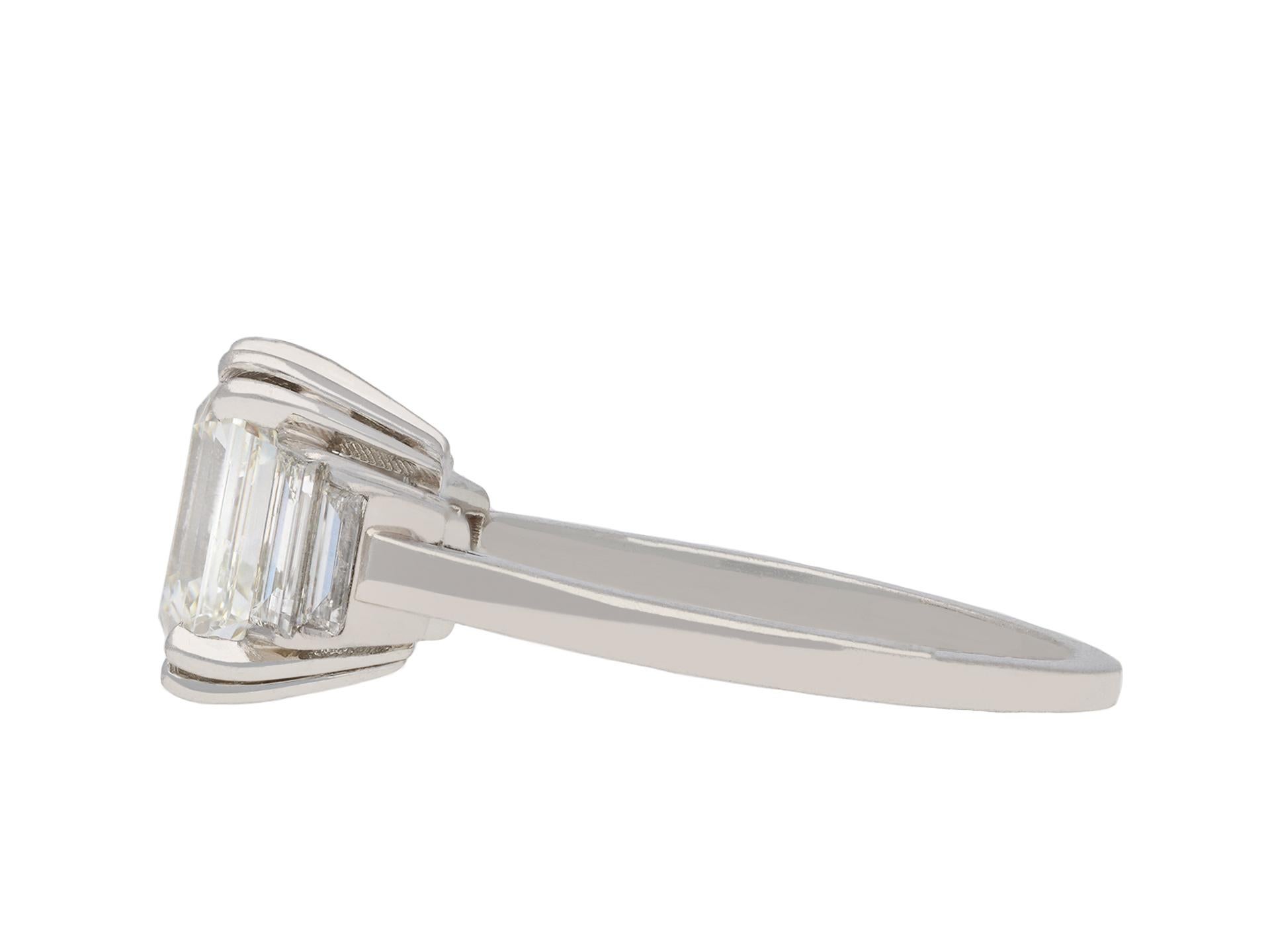 Art Deco diamond flank solitaire ring. Set to centre with an octagonal step cut diamond, I colour, VS1 clarity, with a weight of 2.19 carats, in an open back claw setting, flanked by four rectangular baguette cut diamonds in open back rubover
