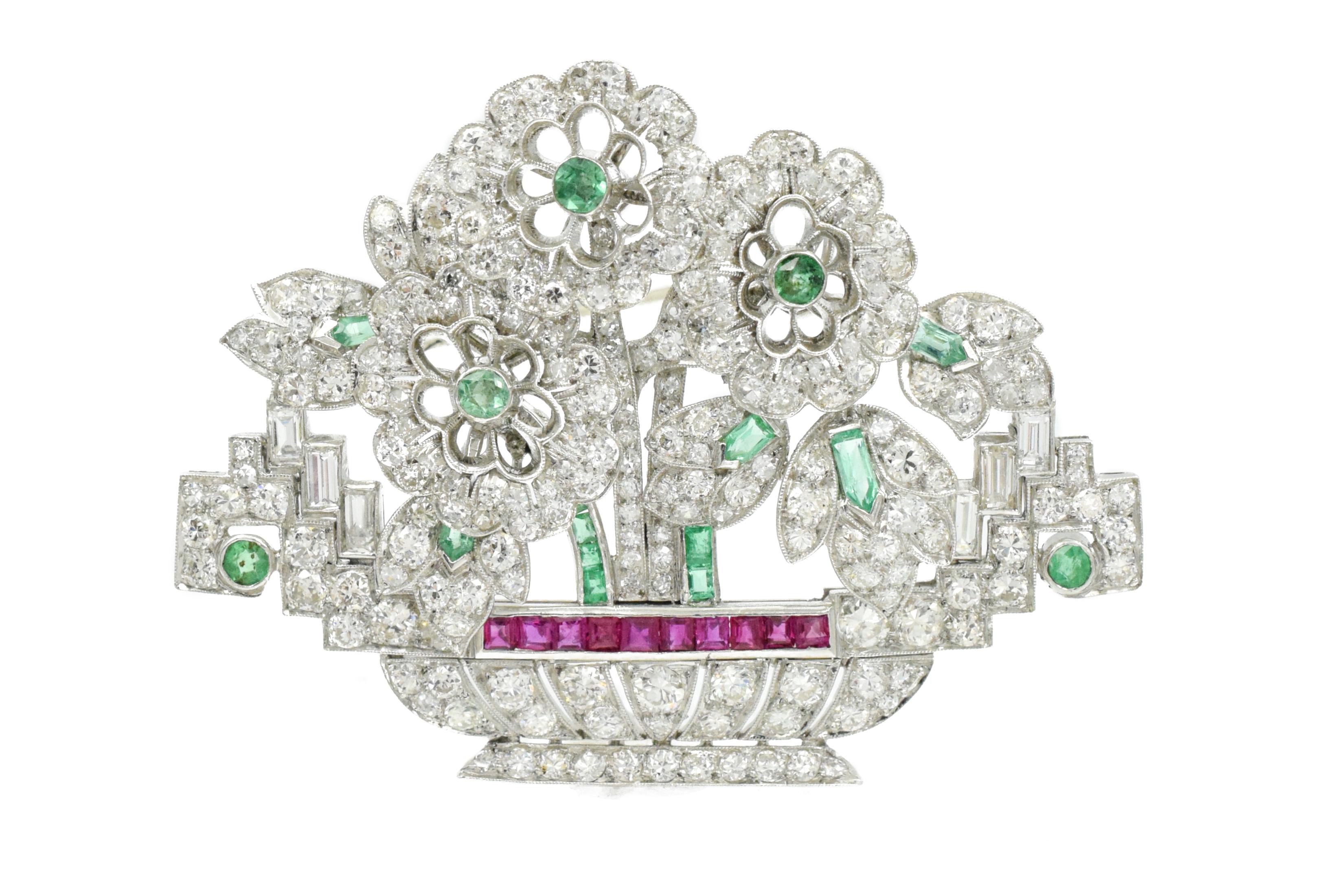 Beautiful art deco brooch with three flowers in the basket encrusted with diamonds .
Estimated total weight of the diamonds is 5 carat
Emeralds are 1.00carat
Rubies are     1.00carat
Platinum;
Measurements: 2.2