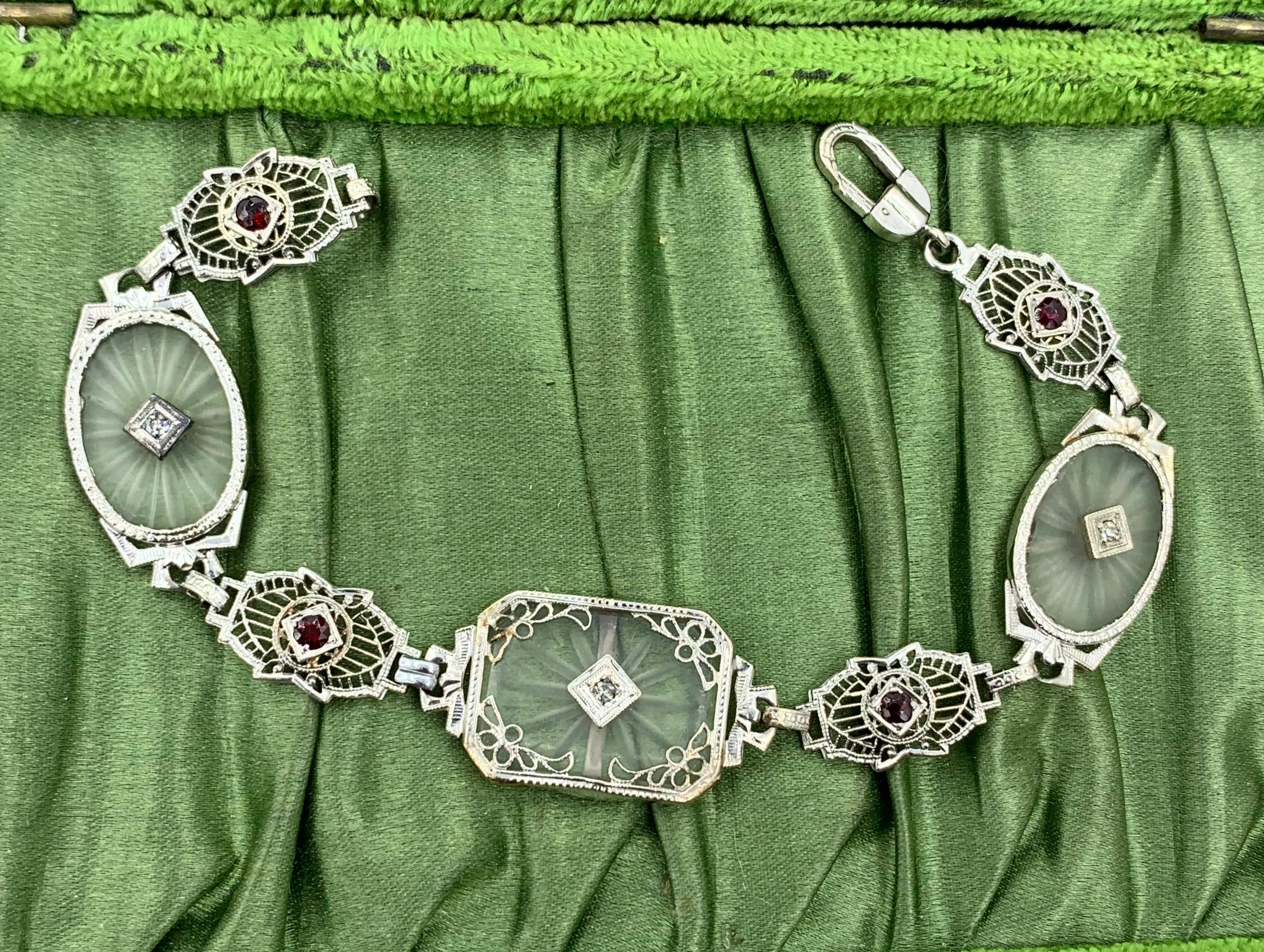 This is a radiant Diamond and Garnet Frosted Rock Quartz Crystal 14 Karat White Gold Bracelet.  The classic antique Art Deco bracelet of great beauty is set with rectangular and oval carved Rock Crystal plaques (also known as camphor glass).  The