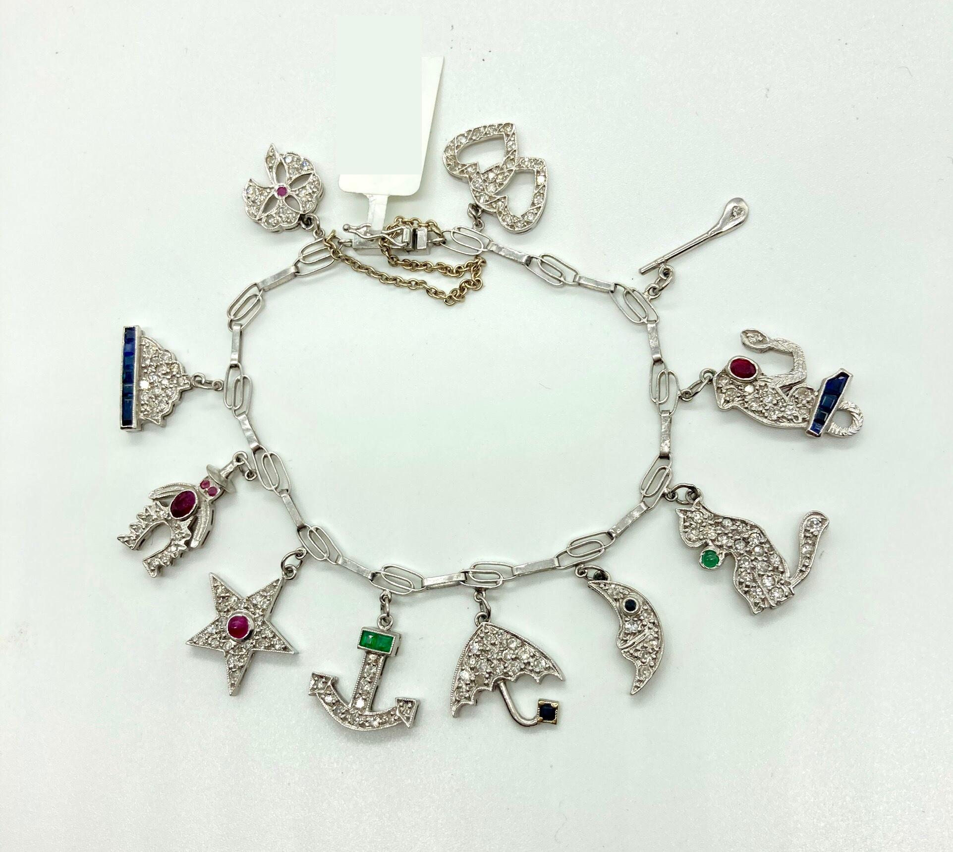 A beautiful white gold charm bracelet from the 1930s embellished with diamonds, emeralds, rubies, and sapphires.