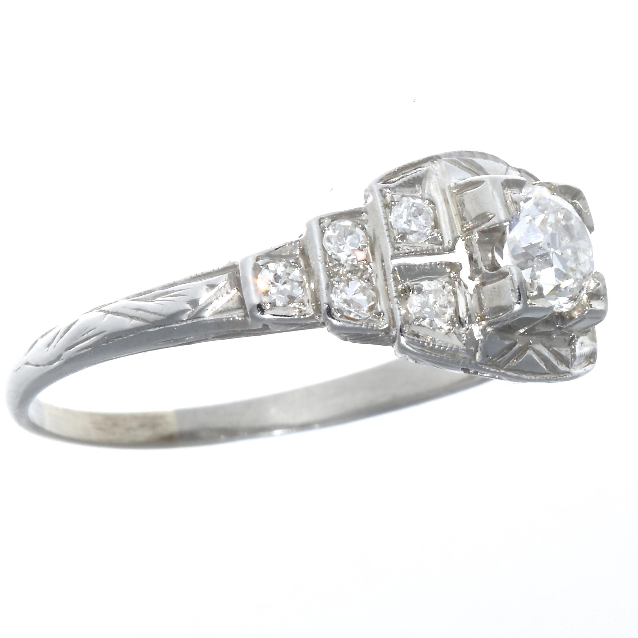 Art Deco, a time of elegance, geometric forms and music to match. All captured in this stylish engagement ring. The center diamond weighs approximately 0.35 carats and is graded as G-H color and SI clarity. Accented with  10 single cut diamonds