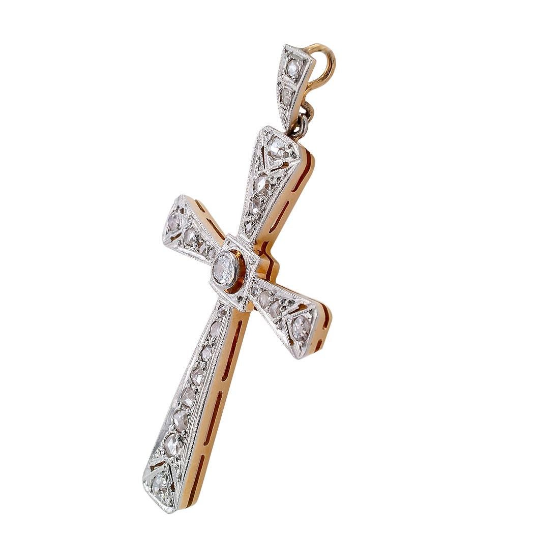 Art Deco diamond gold and platinum cross pendant circa 1930.

DETAILS:
DIAMONDS:  one old mine-cut and twenty-two rose-cut diamonds together weighing approximately 0.50 carat.
METAL:  Platinum topped 18-kt gold.
MEASUREMENTS:  approximately 1 ¾”