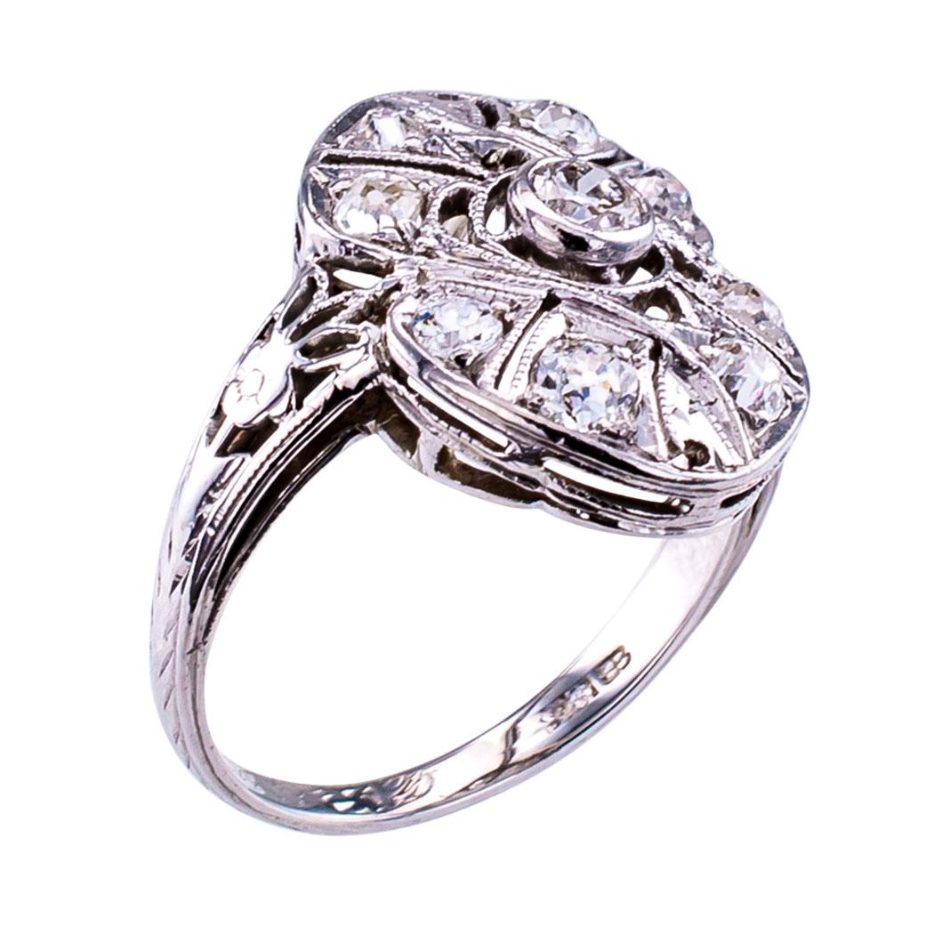 Art Deco diamond gold and platinum dinner ring circa 1920. The petite scale dinner ring design features nine old-cut round diamonds totaling approximately 0.50 carat, approximately H – J color and VS – SI clarity, set on a very slightly domed