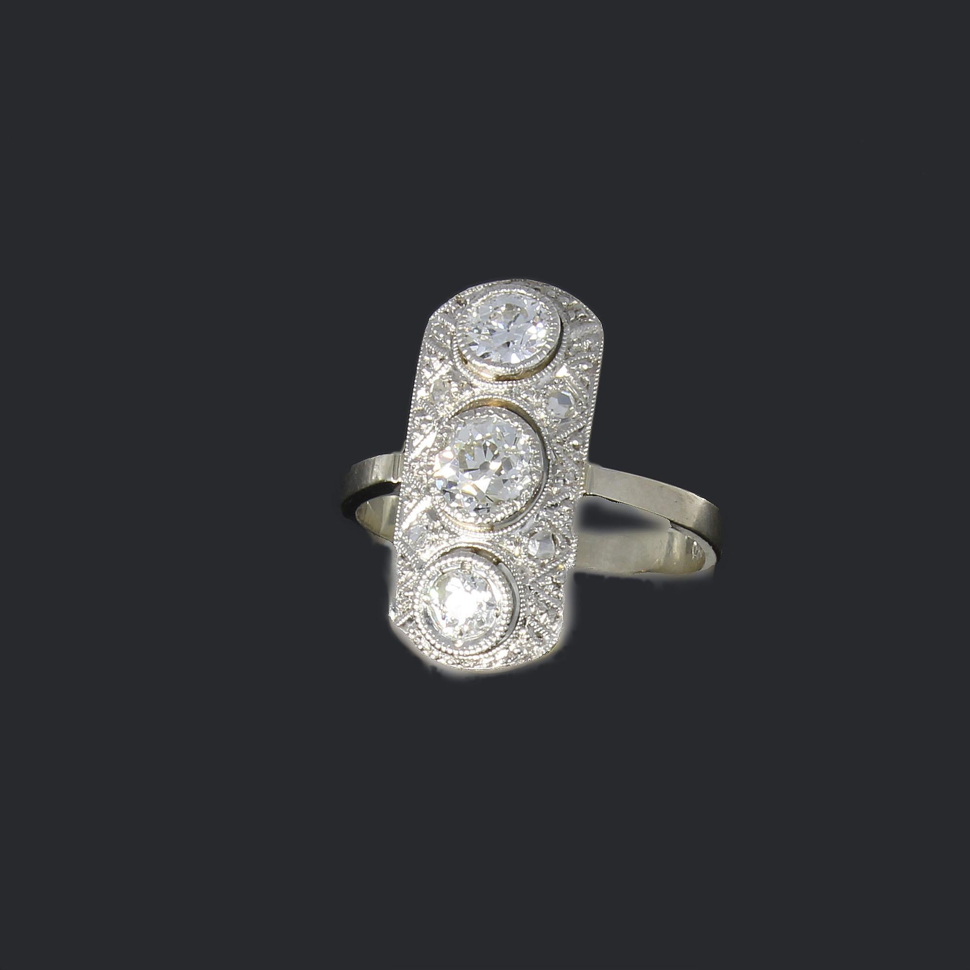 Typically Art Déco style with 7 diamonds. Center stone brilliant-cut diamond weighing ca. 0,52 ct., clarity: S1, color: TW. Two brilliant-cut diamonds weighing circa 0,60 ct, and 4 diamonds. Mounted in 14K white gold. Millegrain setting. Hallmarked