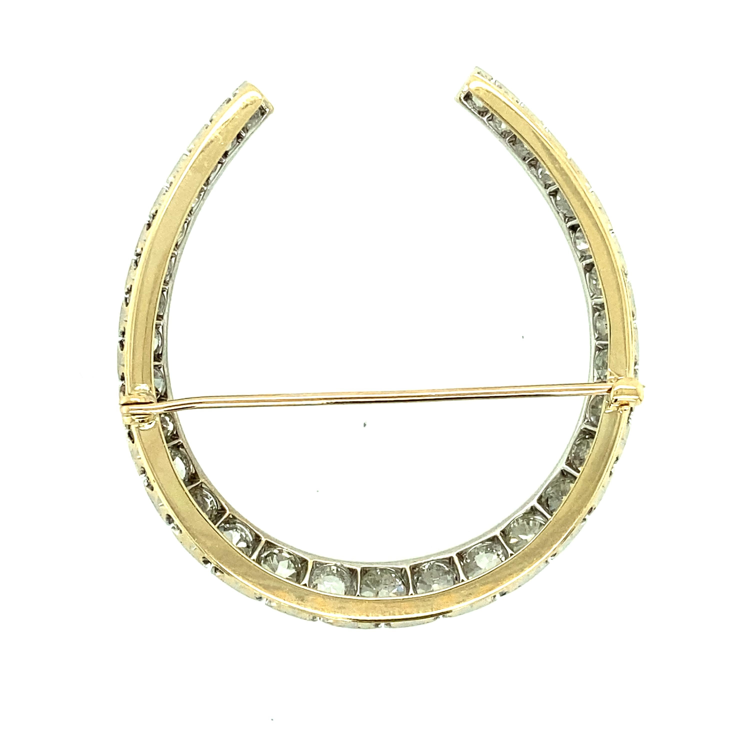 One 14 karat yellow gold and platinum estate horseshoe design pin set with thirty-two Old Mine cut diamonds, approximately 6.5 carat total weight with matching J/K color and VS/SI1 clarity.  The pin measures 2 inches long and is complete with a