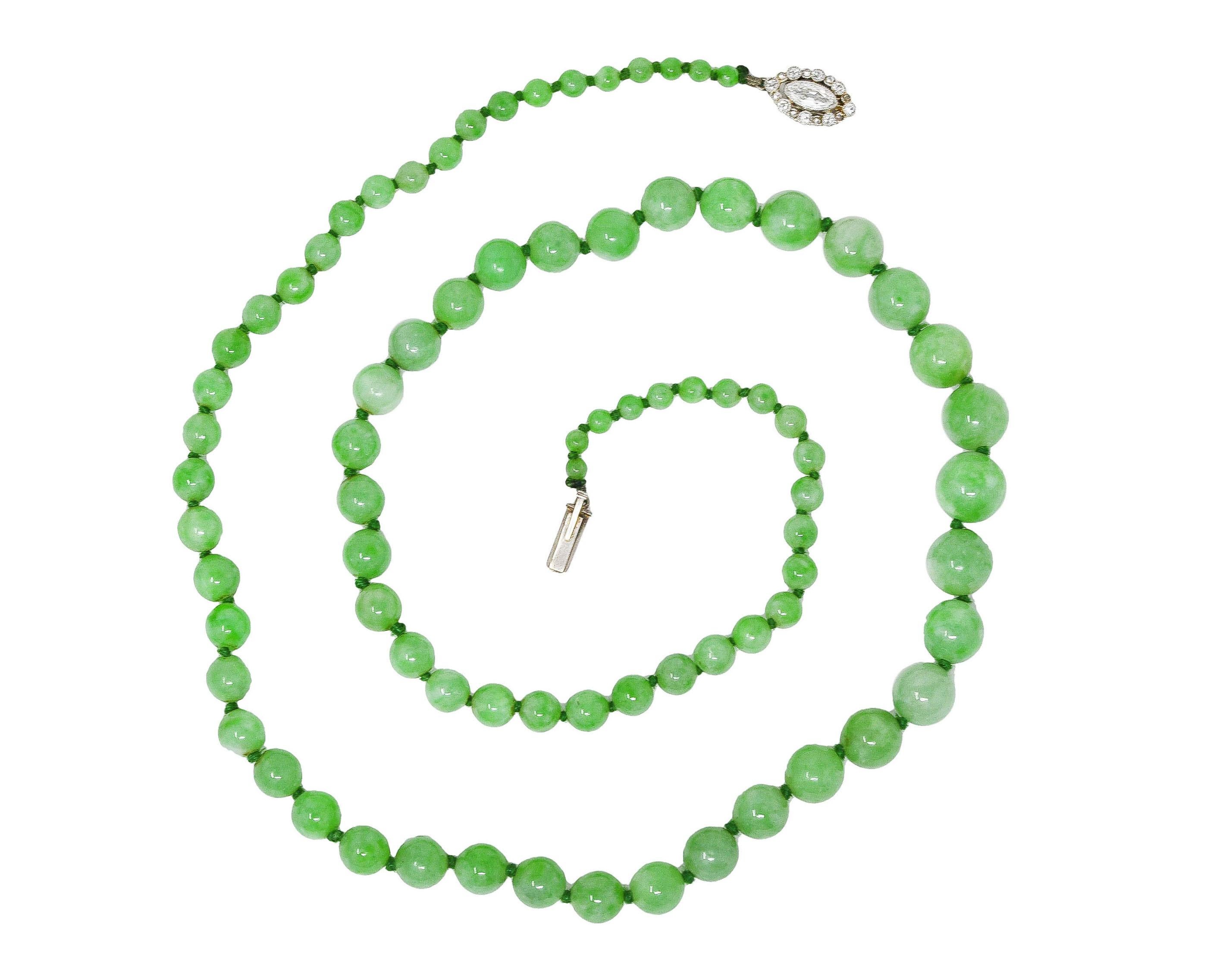 Strand necklace is hand knotted with jadeite jade beads. Graduating in size from 9.0 mm to 3.0 mm. Very well matched in translucent green to pastel light green color - moderately strong mottling. Terminating as a platinum cluster clasp with a