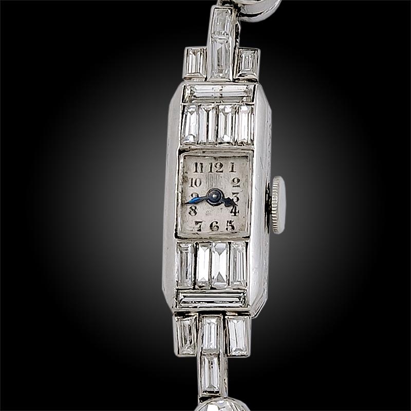 Montre Art Déco vintage en platine pour femme, avec un boîtier intemporel de forme baguette, rehaussé de quatre diamants de forme baguette au-dessus et au-dessous du cadran, et un bracelet exquis comprenant une alternance de diamants ronds et de