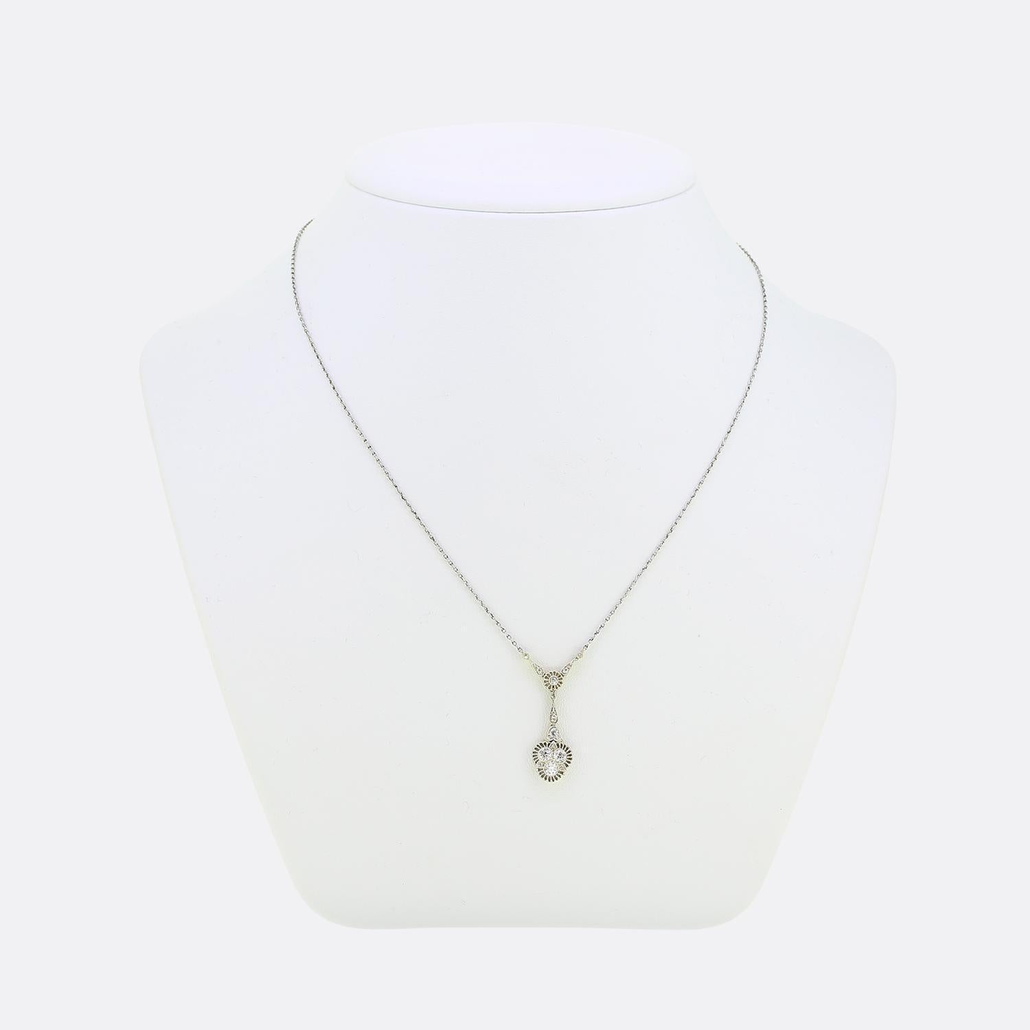 Nous avons ici un charmant collier de lavallière réalisé à une époque où le style Art déco était à son apogée. Ce pendentif en forme de goutte a été réalisé en or jaune 18 ct avec des pointes en platine. Un trio de diamants de taille européenne