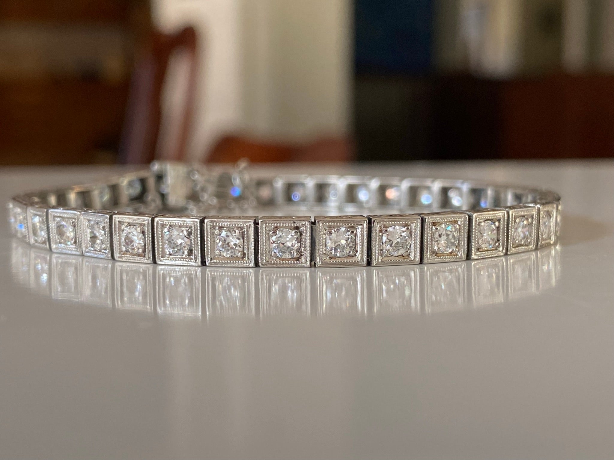 Crafted in the 1930s in platinum, this dazzling Art Deco link bracelet is designed around thirty-seven natural Old European cut diamonds in a square setting accented with delicate milgraining and an intricate floral motif hand engraved on the sides.