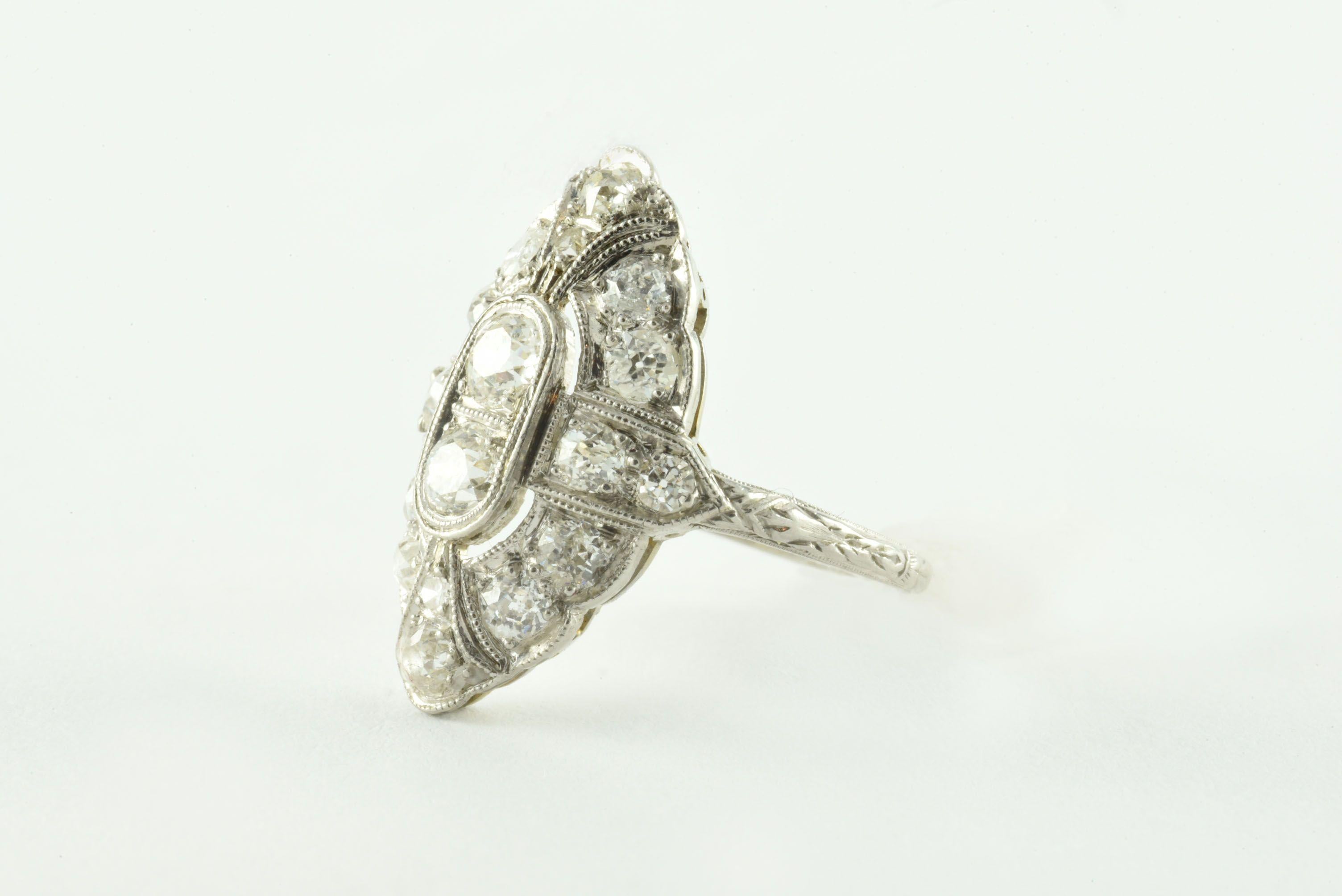 Crafted in the 1920s from platinum, this dazzling Art Deco gem features eighteen Old European cut diamonds, F-G color, VS-SI clarity within a navette-shaped frame, totaling approximately 1.00 carat and accented with delicate milgraining and engraved