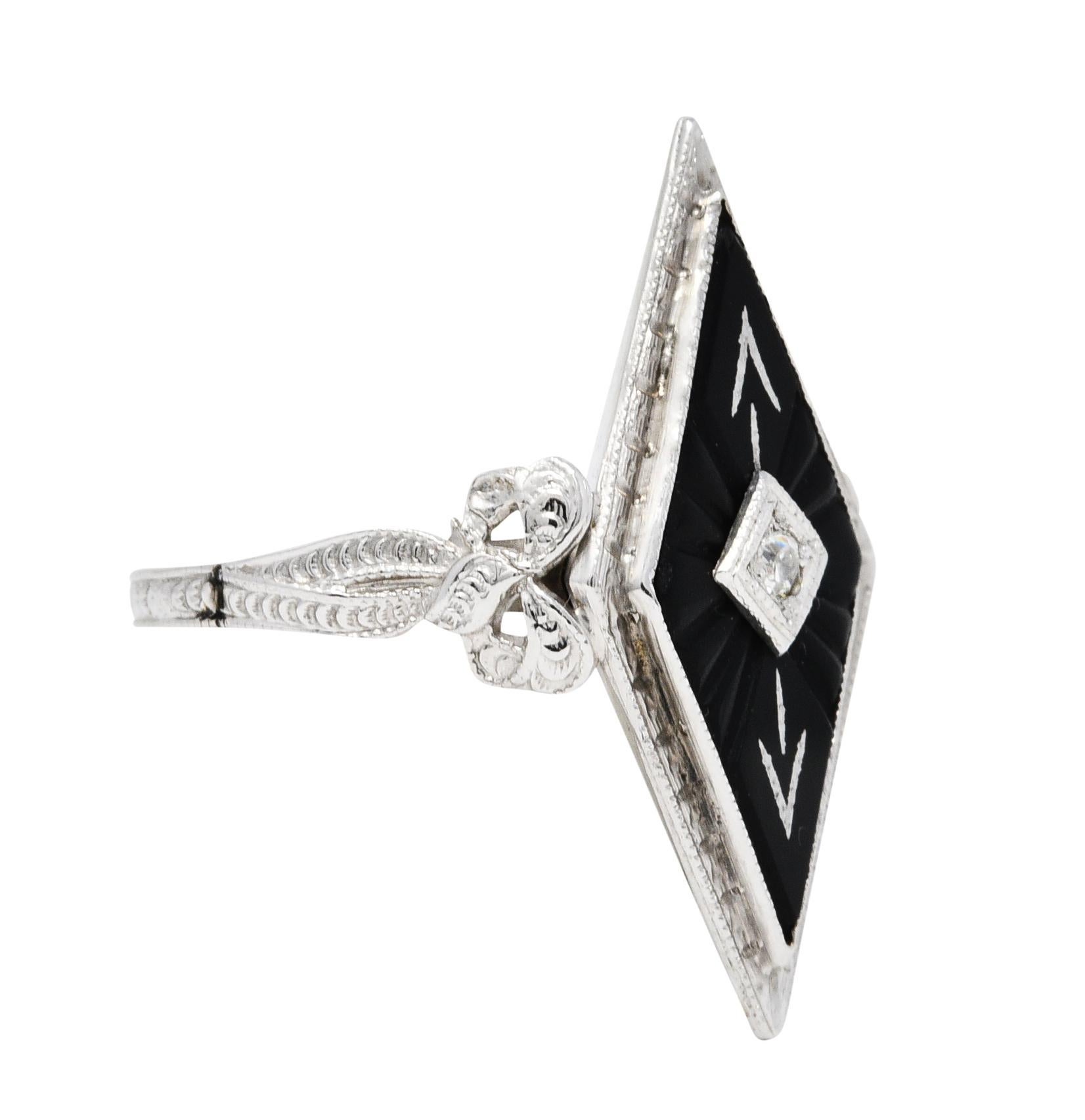 Navette shaped dinner ring centers an old single cut diamond weighing approximately 0.03 carat

Inset in a white gold square form head with an onyx surround

Deeply carved with a radiated burst motif and stylized arrows accented by white gold