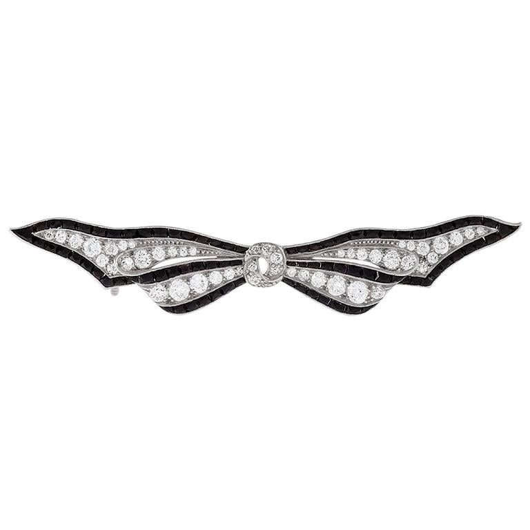 Art Deco Diamond Onyx and Platinum Bow Brooch For Sale