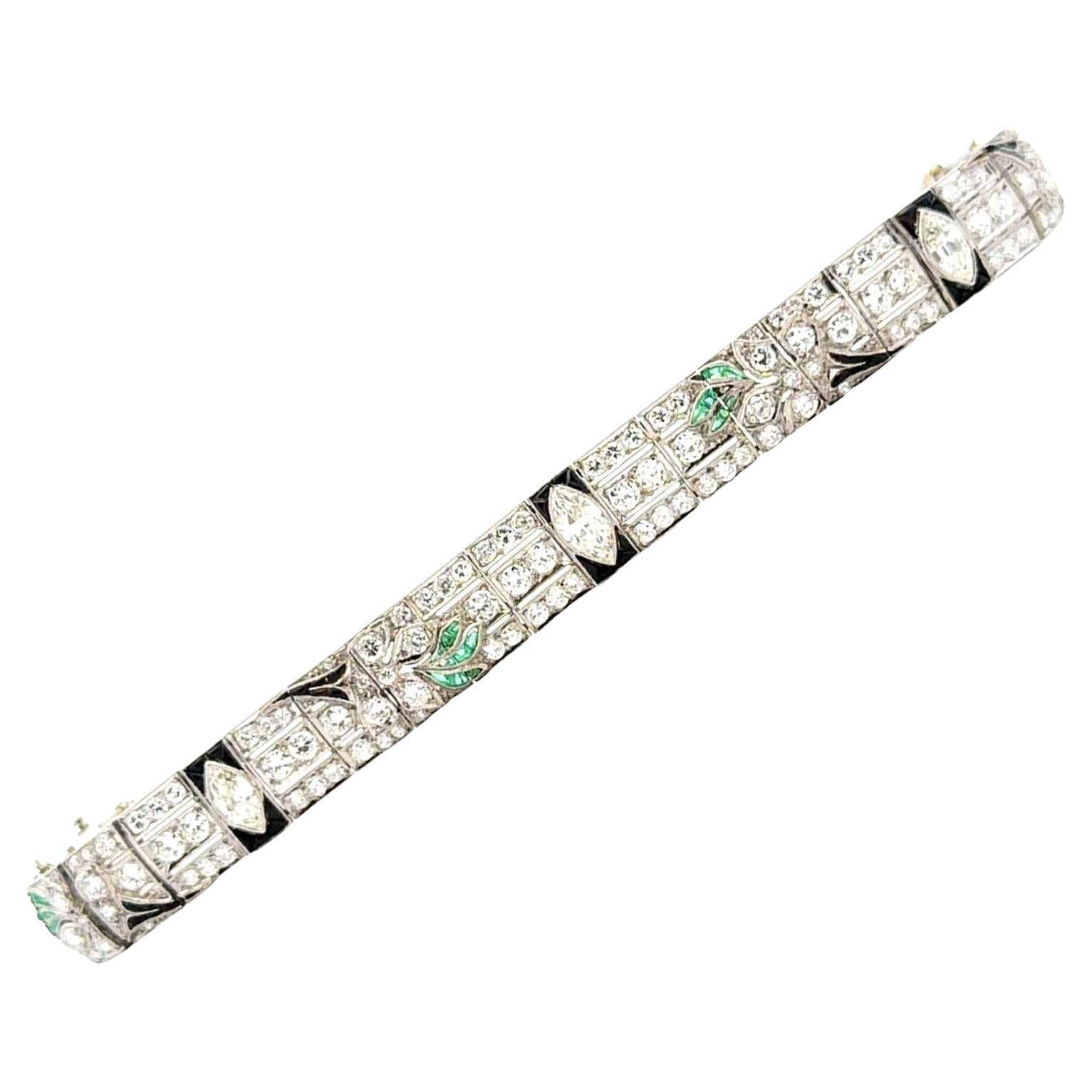 Dieses exquisite Platinarmband im Art-Déco-Stil fängt den Glamour und die aufwendige Handwerkskunst der Epoche mit einer atemberaubenden Kombination aus Diamanten, Onyx und Smaragden ein. In der Mitte befindet sich ein Diamant im Marquiseschliff mit