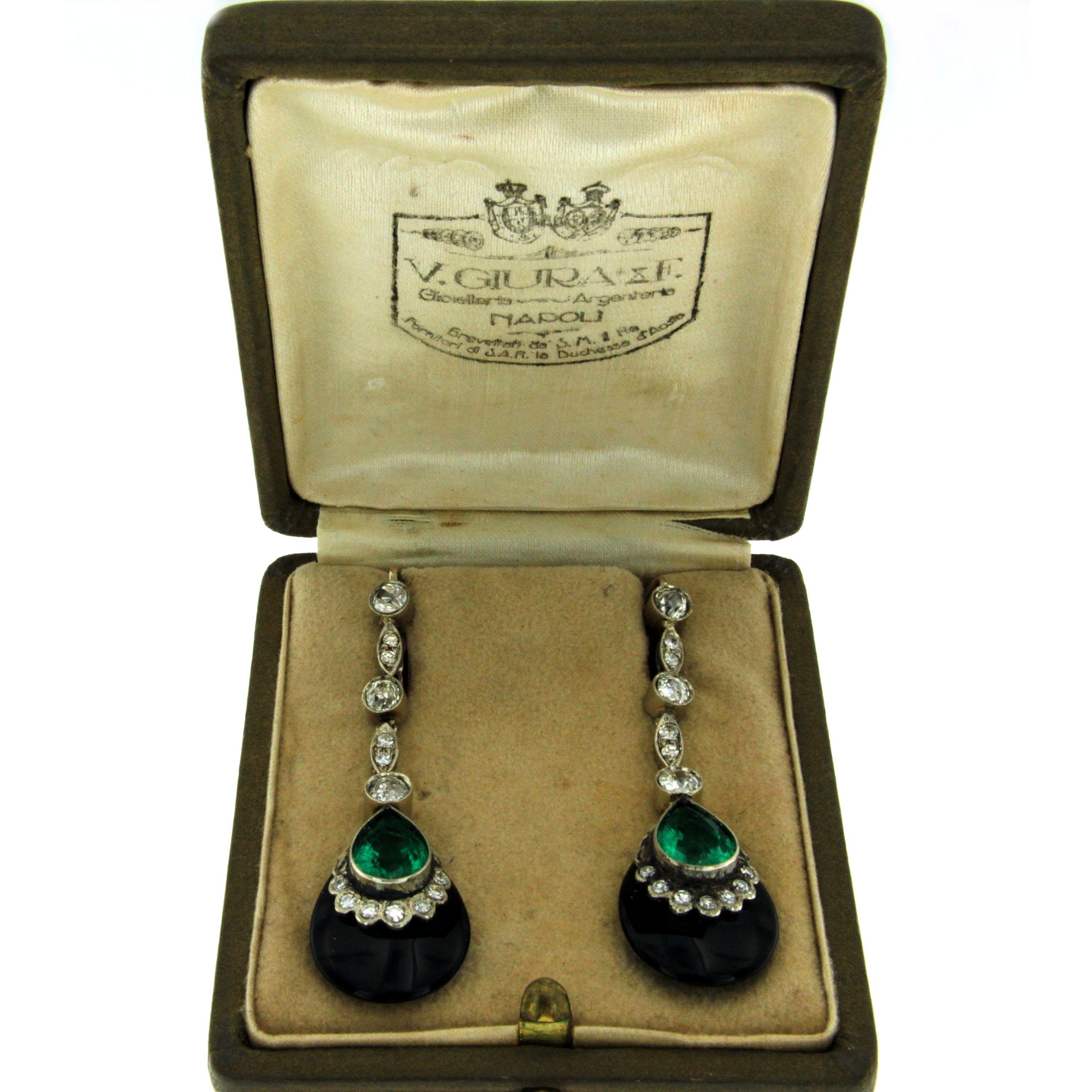 A pair of 18k white gold hand-made pendant earrings, authentic art deco, dated 1930. 
Each earring features a large vivid, drop Emerald Green composite stone, set with 1.50 carats of old mine cut cut diamonds, graded I/J color Vs clarity, in an Onyx