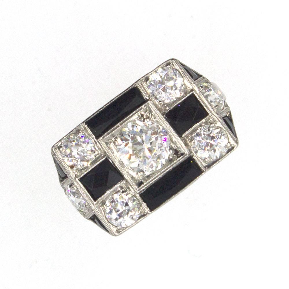 This gorgeous original Art Deco ring is circa 1920's. The beautifully crafted ring is platinum and features a checkerboard top with diamonds and onyx.  An Old Mine Cut center diamond (.93 carats) along with 6 side diamonds weigh a total of