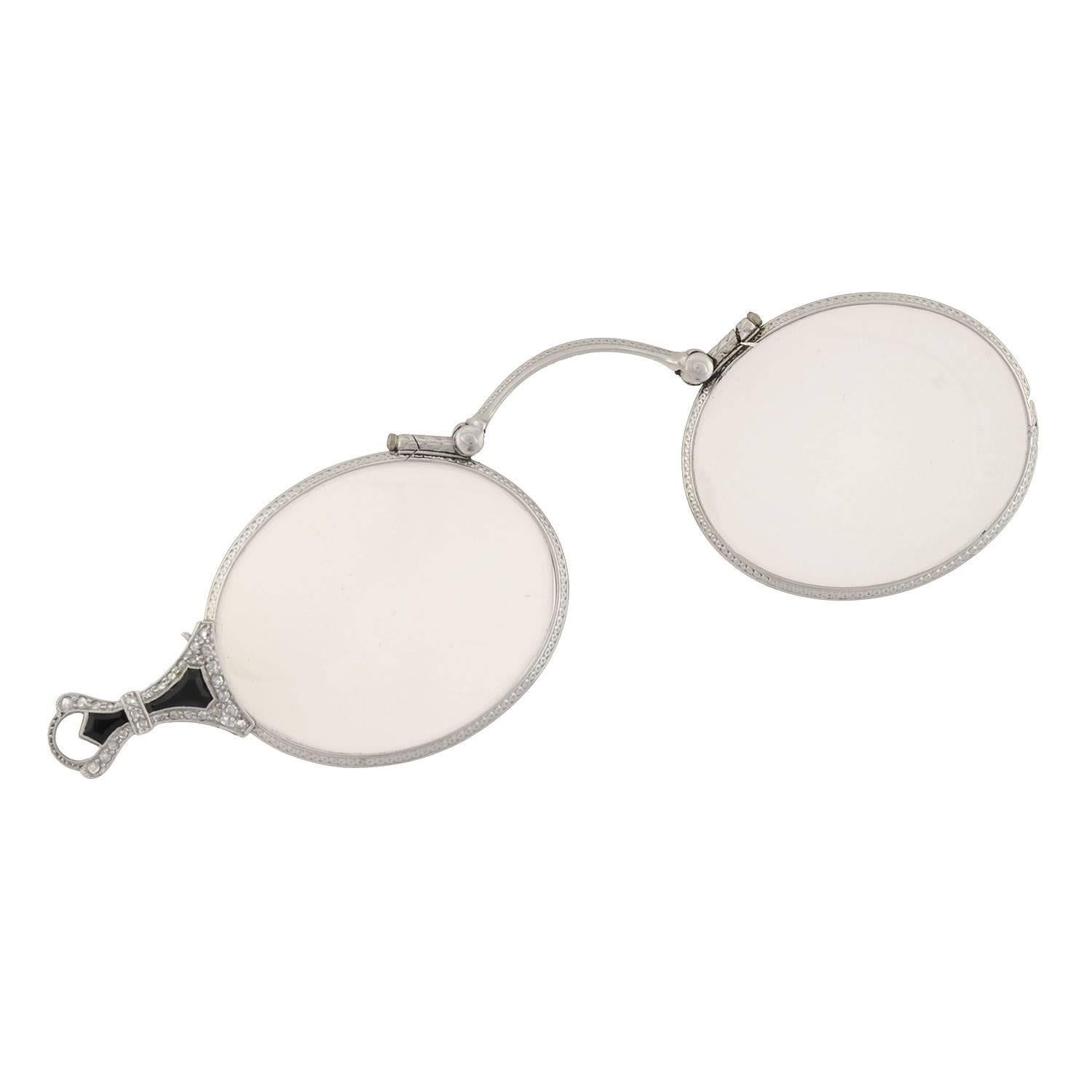 An elegant lorgnette pendant from the Art Deco (ca1920) era! This platinum pendant doubles as an expandable pair of lorgnette glasses. The glass lenses (non-prescription) are encased within platinum borders, which have been embellished with an