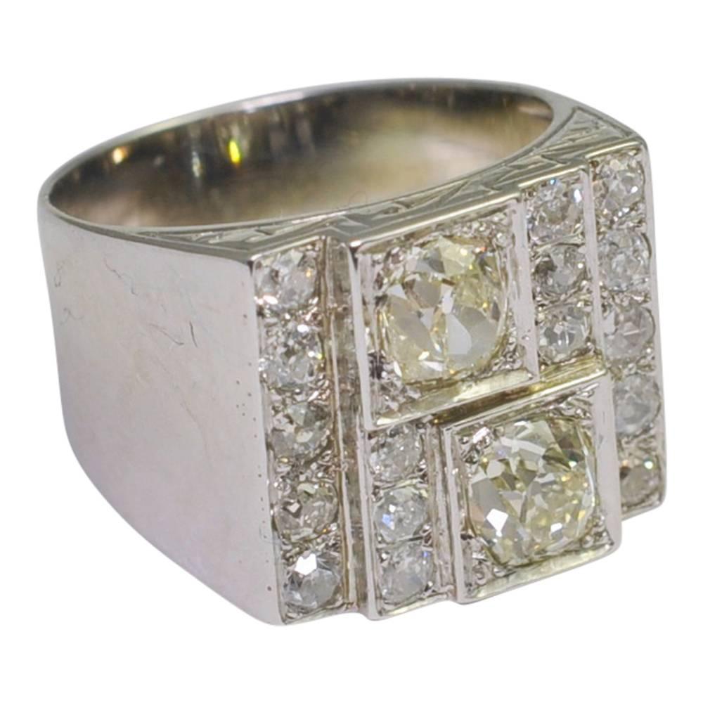 Stylish Art Deco diamond panel ring set with two chunky Old European cut diamonds each weighing 0.75ct and a further 0.80ct of smaller Old European cut diamonds which are set in a stepped design. The two larger diamonds have a hint of colour which