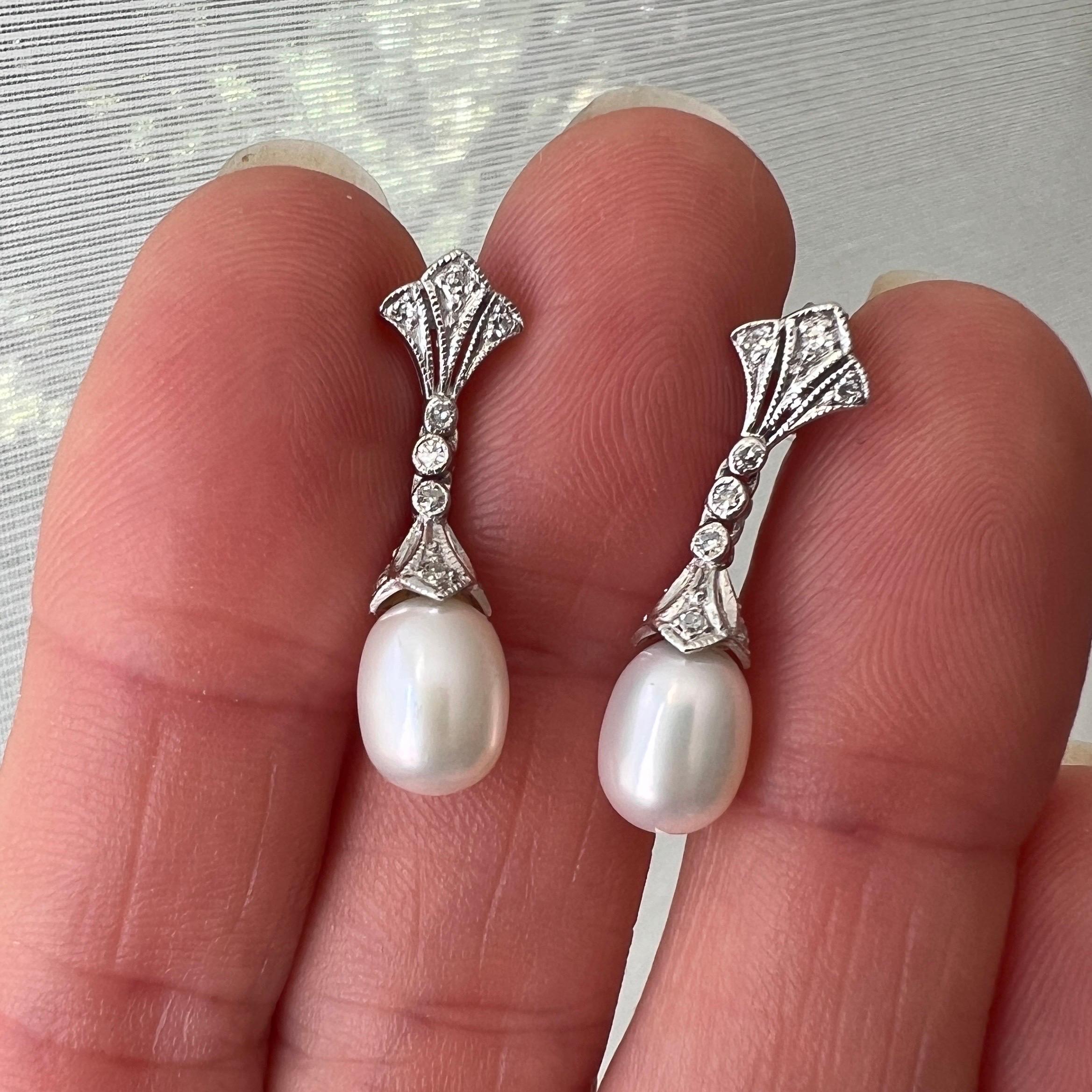 These lovely Art Deco 14 karat white gold earrings are set with a drop-shaped pearl. The upper part of the earrings are shaped into a fan, set with brilliant cut diamonds and mille griffe white gold. The mid-section consists of three movable links,